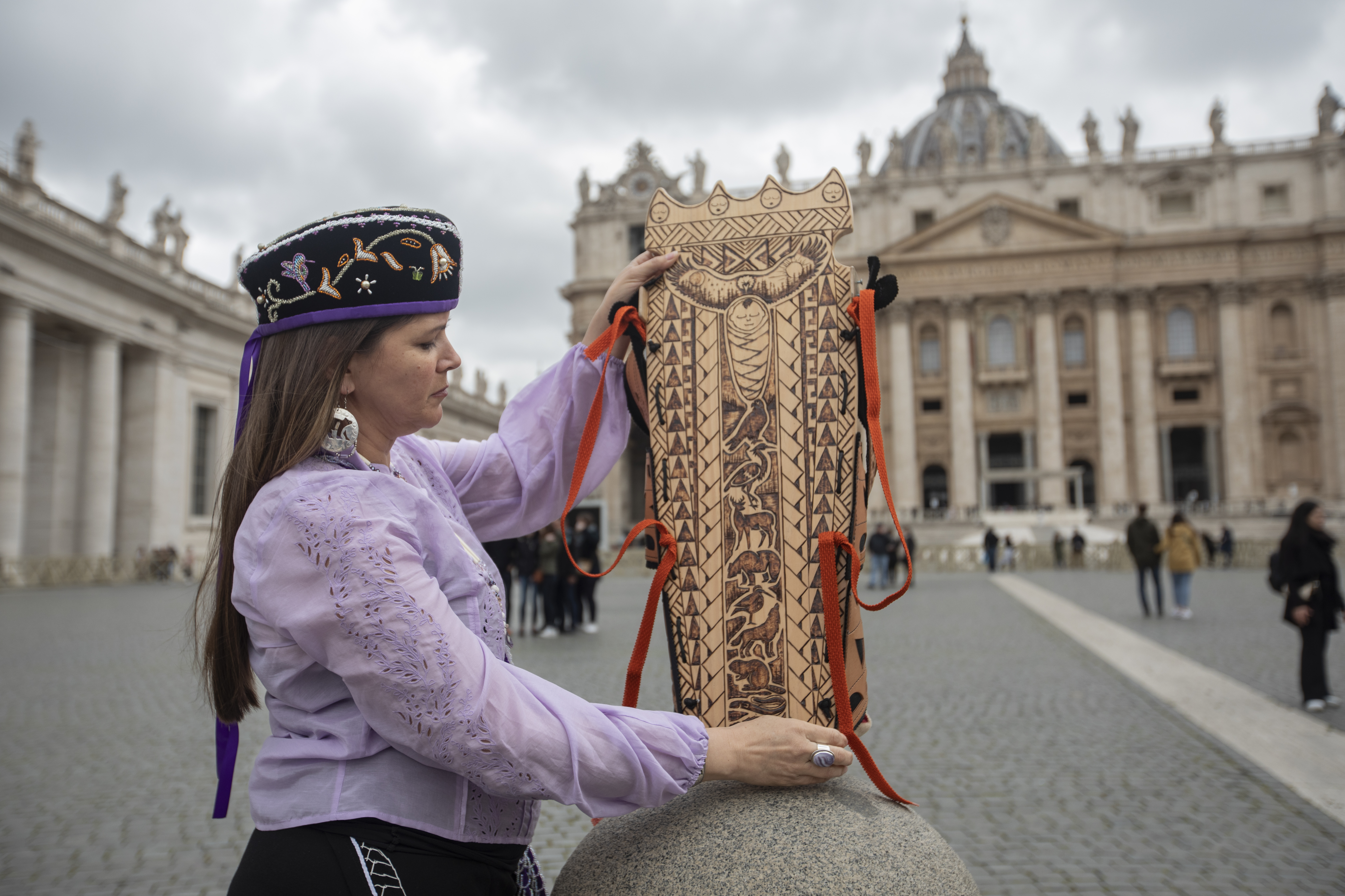 A photo of Michelle Schenandoah holding an empty cradle board.