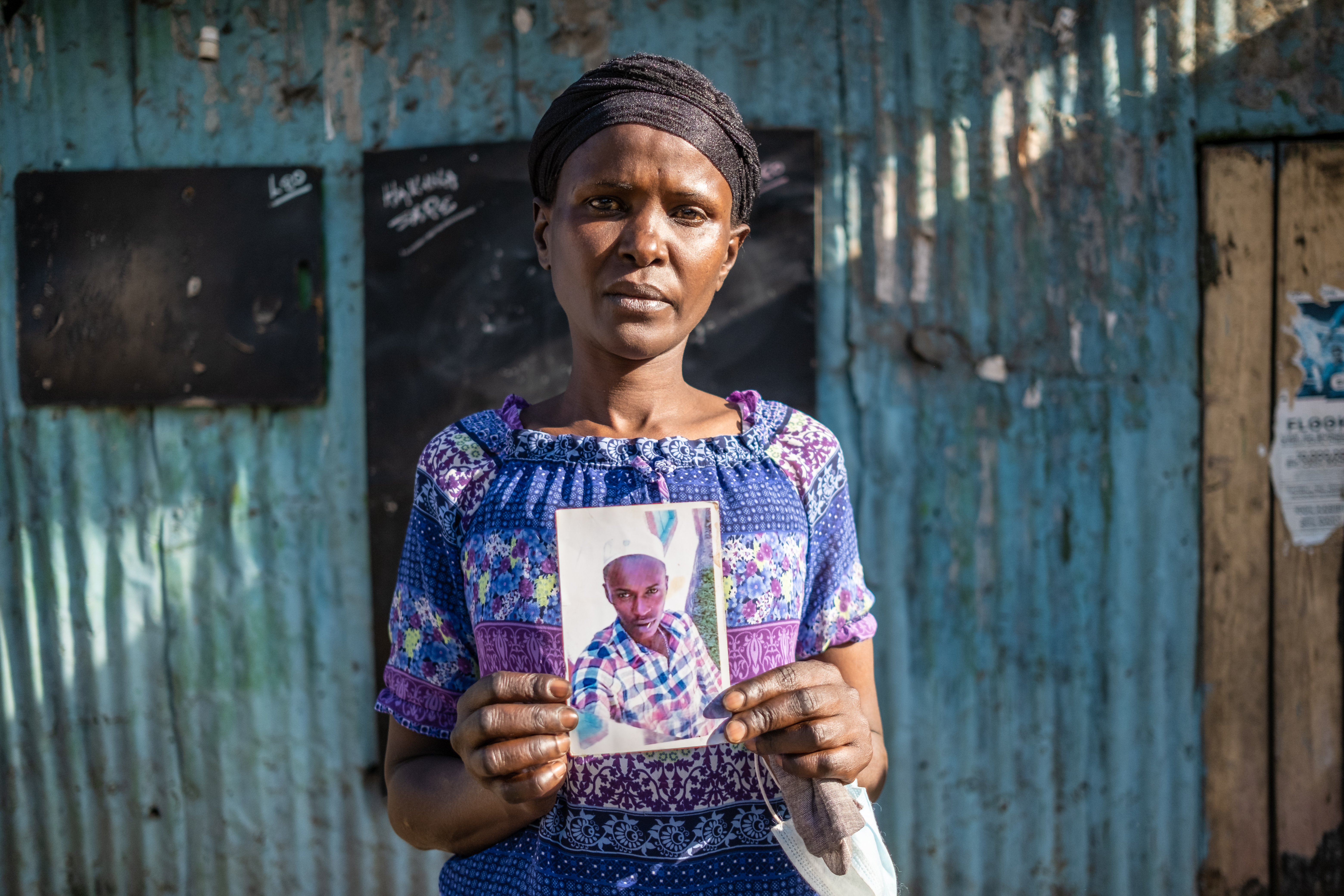 A photo of Lilian Njeri holding a photo of her slain son Anthony Kinuthia.