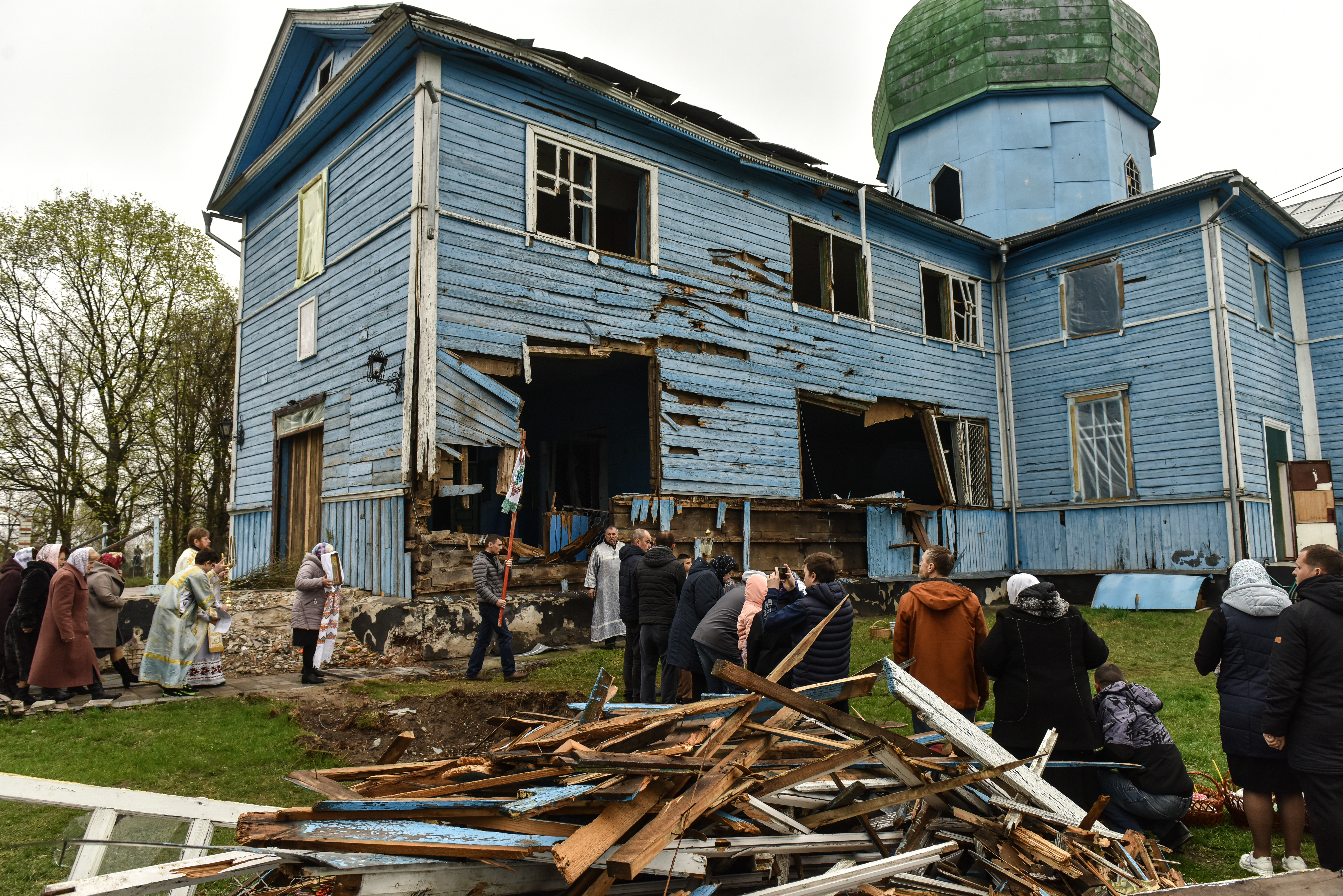 Faithfuls attend an Orthodox Easter service outside the damaged Church of the Nativity of the Virgin in Peremoha village, Ukraine.
