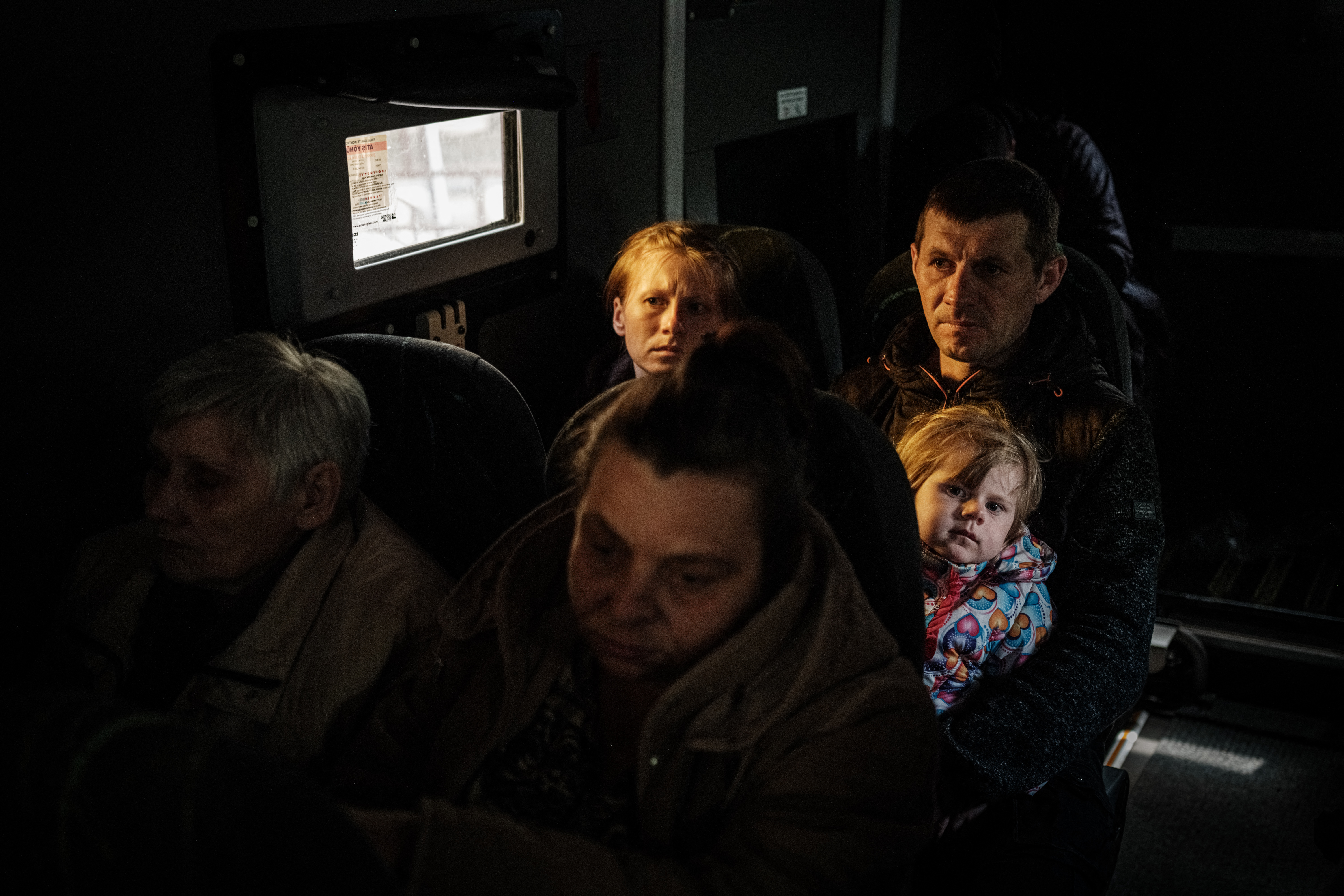 Father, mother and son evacuate in a bulletproof bus with small windows from the eastern Ukraine city of Lyman amid heavy shelling