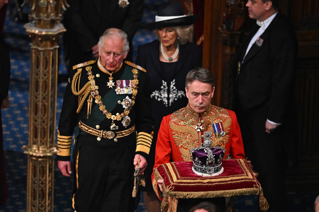 Britain's Prince Charles (L) and Britain's Camilla, Duchess of Cornwall (C) follow behind the Imperial State Crown in the House of Lords Chamber during the State Opening of Parliament in the Houses of Parliament in London