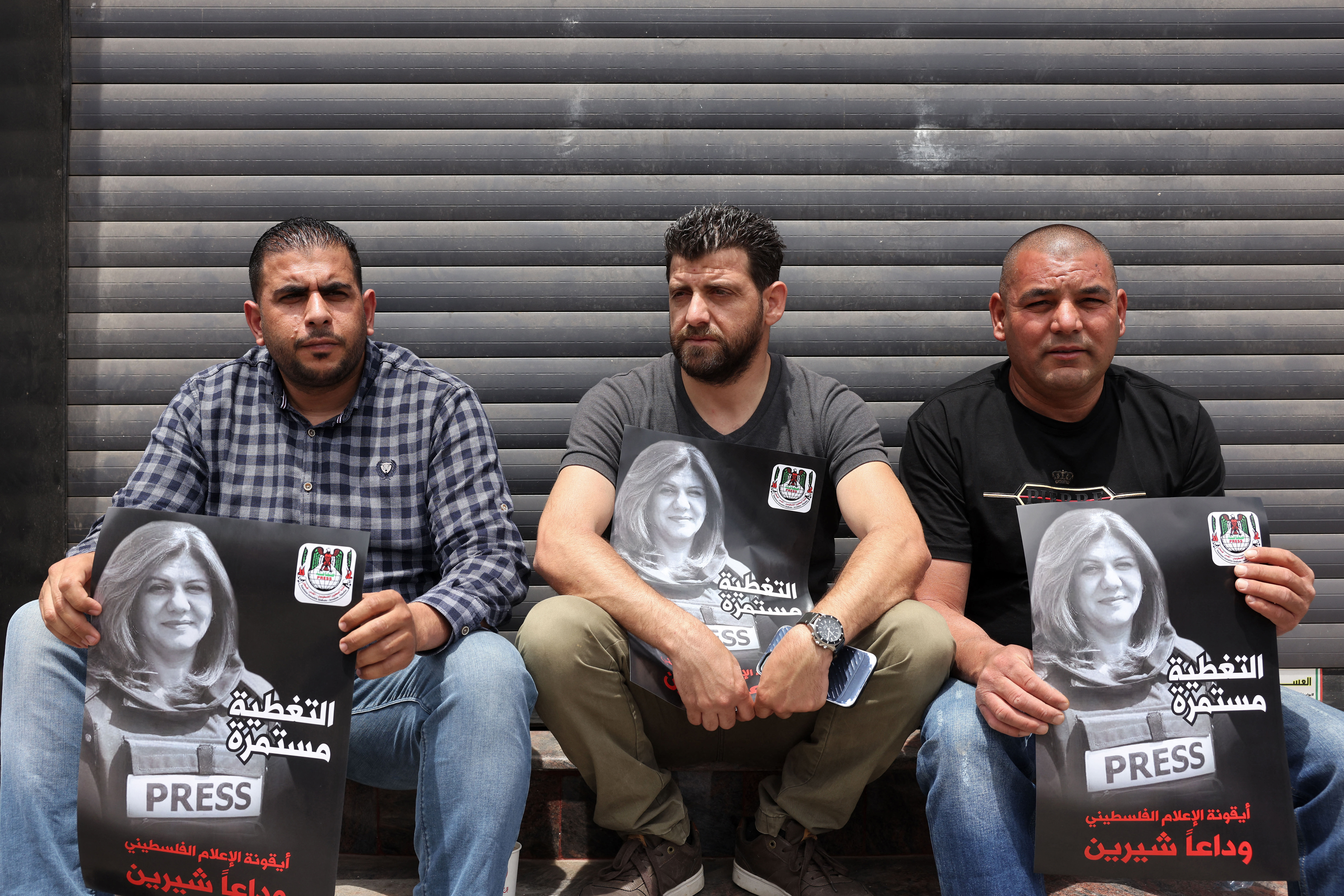 People hold posters of slain Al Jazeera journalist Shireen Abu Akleh