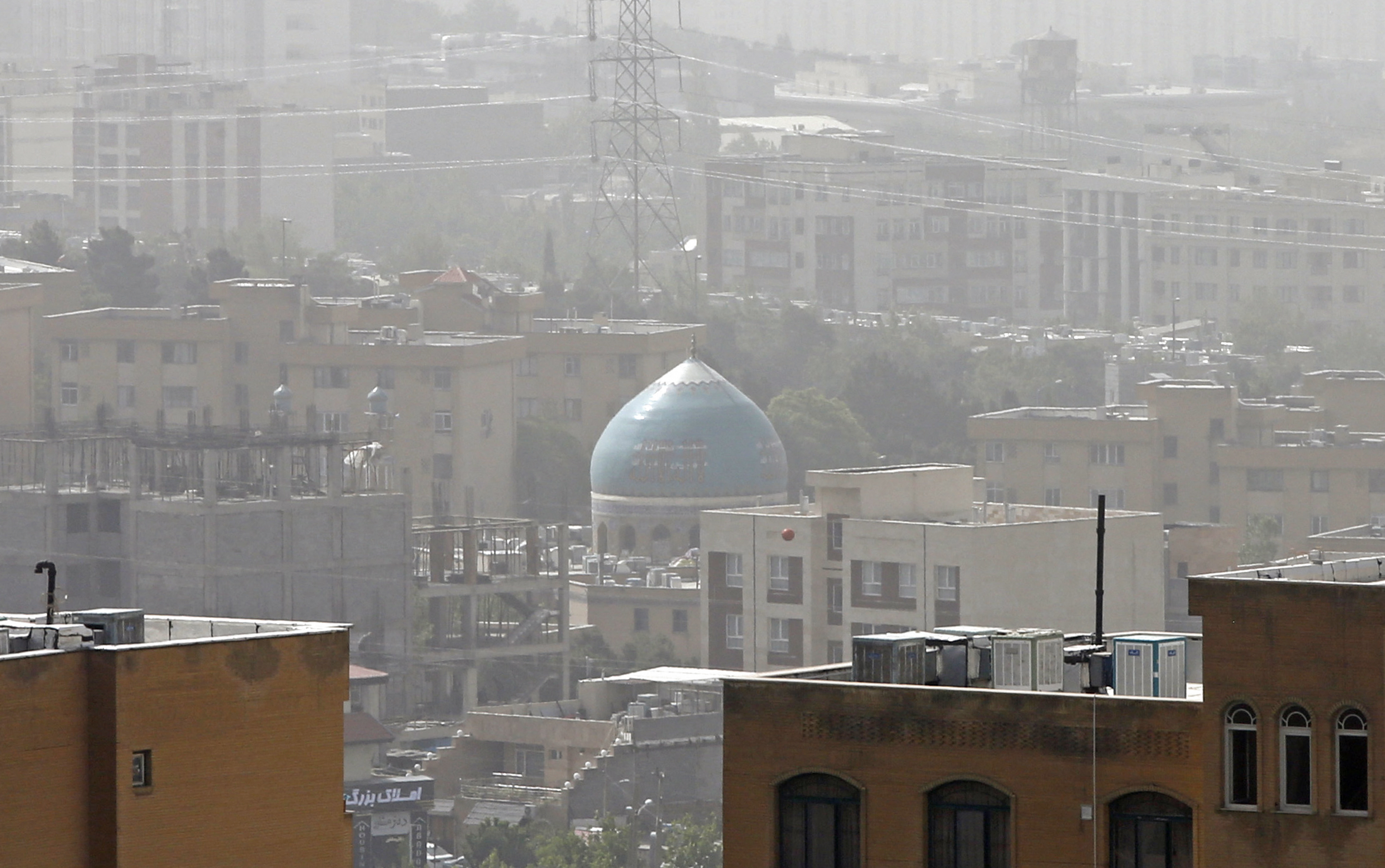 A sandstorm engulfs a mosque in Iran's capital Tehran on May 17, 2022. - Government offices, as well as schools and universities were announced closed in many provinces in Iran due to "unhealthy weather" conditions and sandstorms, state media reported.