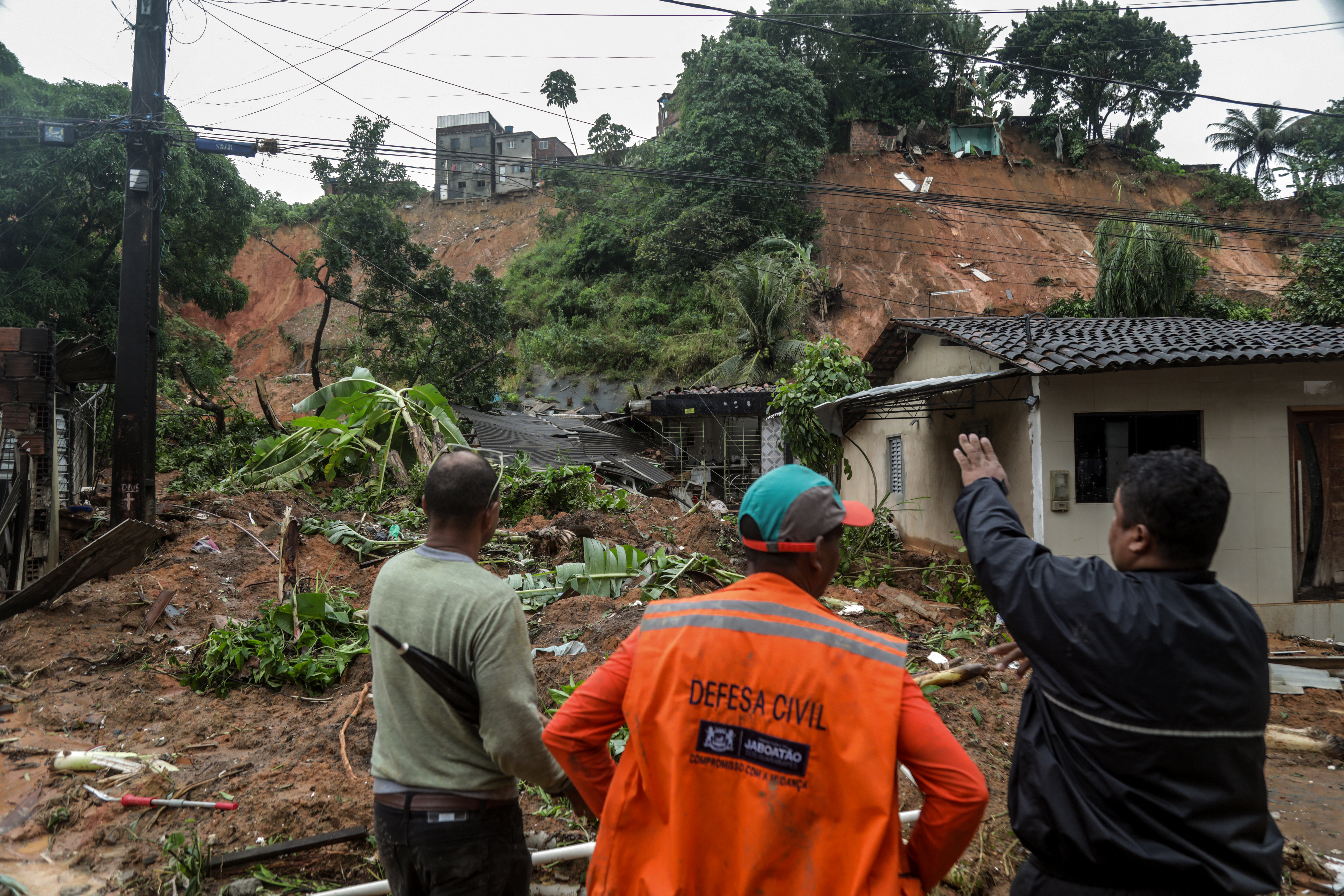 This handout picture release by the Recife City Hall shows people looking at the destruction caused by a landslide in the community Jardim Monte Verde, Ibura neighbourhood, in Recife, Pernambuco State, Brazil, on May 28, 2022. - Torrential rains that have plagued Brazil's northeastern Pernambuco state since Tuesday have left at least 34 dead, 29 of which occurred over the last 24 hours, according to the latest official update. (Photo by Diego NIGRO / RECIFE CITY HALL / AFP) / RESTRICTED TO EDITORIAL USE - MANDATORY CREDIT "AFP PHOTO / RACIFE CITY HALL / DIEGO NIGRO" - NO MARKETING - NO ADVERTISING CAMPAIGNS - DISTRIBUTED AS A SERVICE TO CLIENTS
