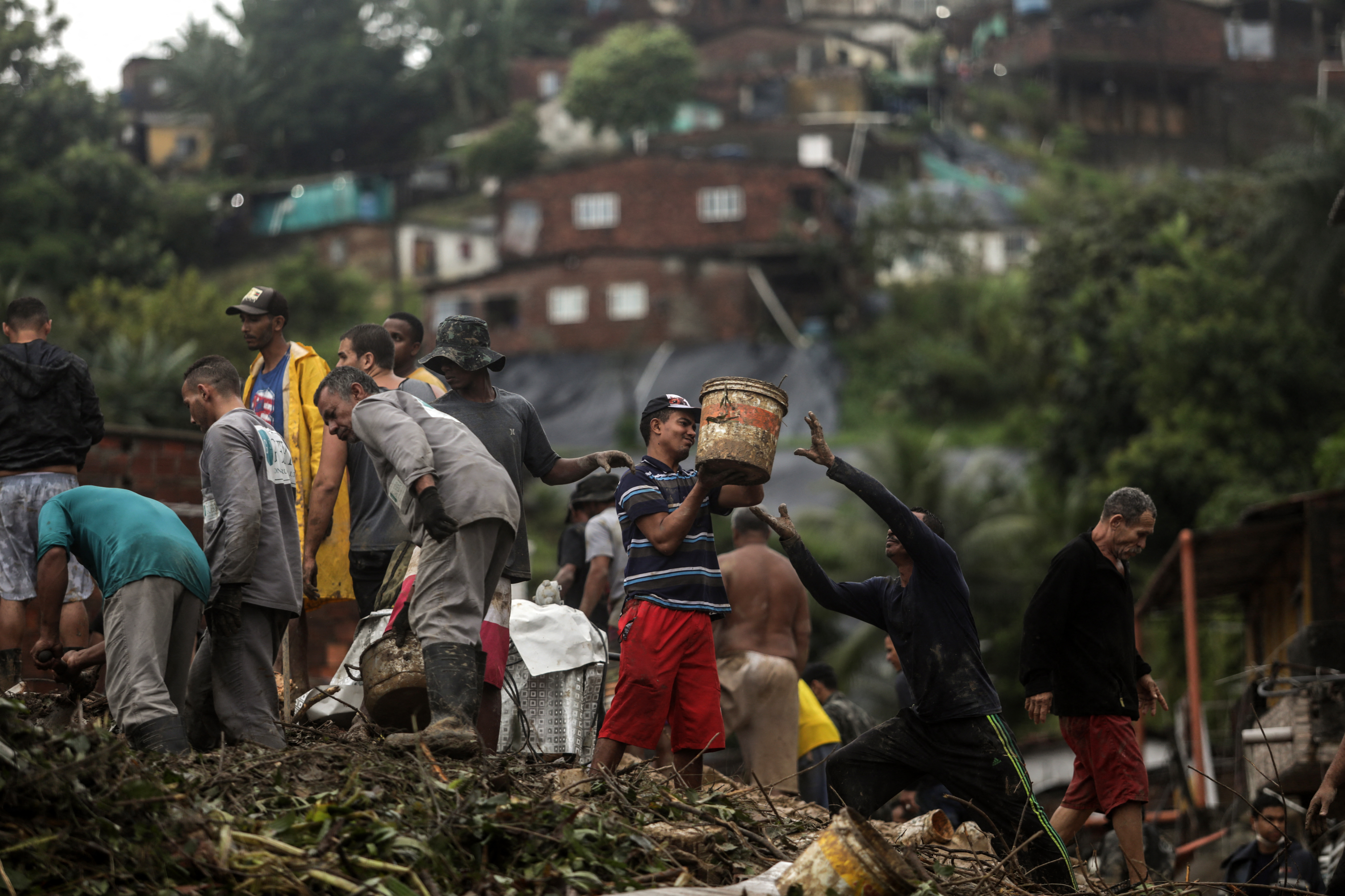 This handout picture release by the Recife City Hall shows residents and rescue workers walking amid the debris of a landslide that destroyed several houses in the community Jardim Monte Verde, Ibura neighbourhood, in Recife, Pernambuco State, Brazil, on May 28, 2022. - Torrential rains that have plagued Brazil's northeastern Pernambuco state since Tuesday have left at least 34 dead, 29 of which occurred over the last 24 hours, according to the latest official update. (Photo by Diego NIGRO / RECIFE CITY HALL / AFP) / RESTRICTED TO EDITORIAL USE - MANDATORY CREDIT "AFP PHOTO / RACIFE CITY HALL / DIEGO NIGRO" - NO MARKETING - NO ADVERTISING CAMPAIGNS - DISTRIBUTED AS A SERVICE TO CLIENTS