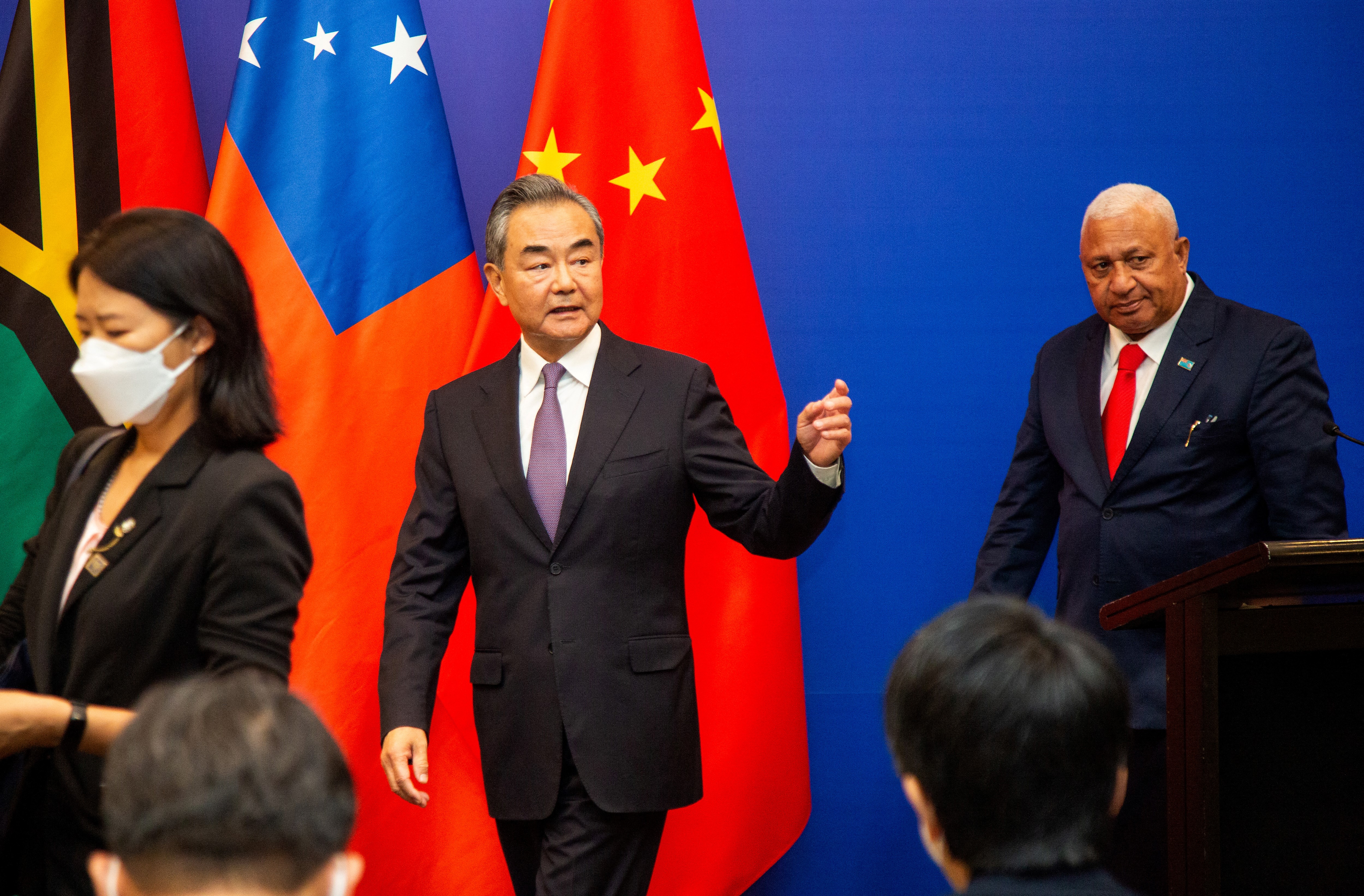 Chinese Foreign Minister Wang Yi (C) leaves after a joint press conference with Fijian Prime Minister Frank Bainimarama