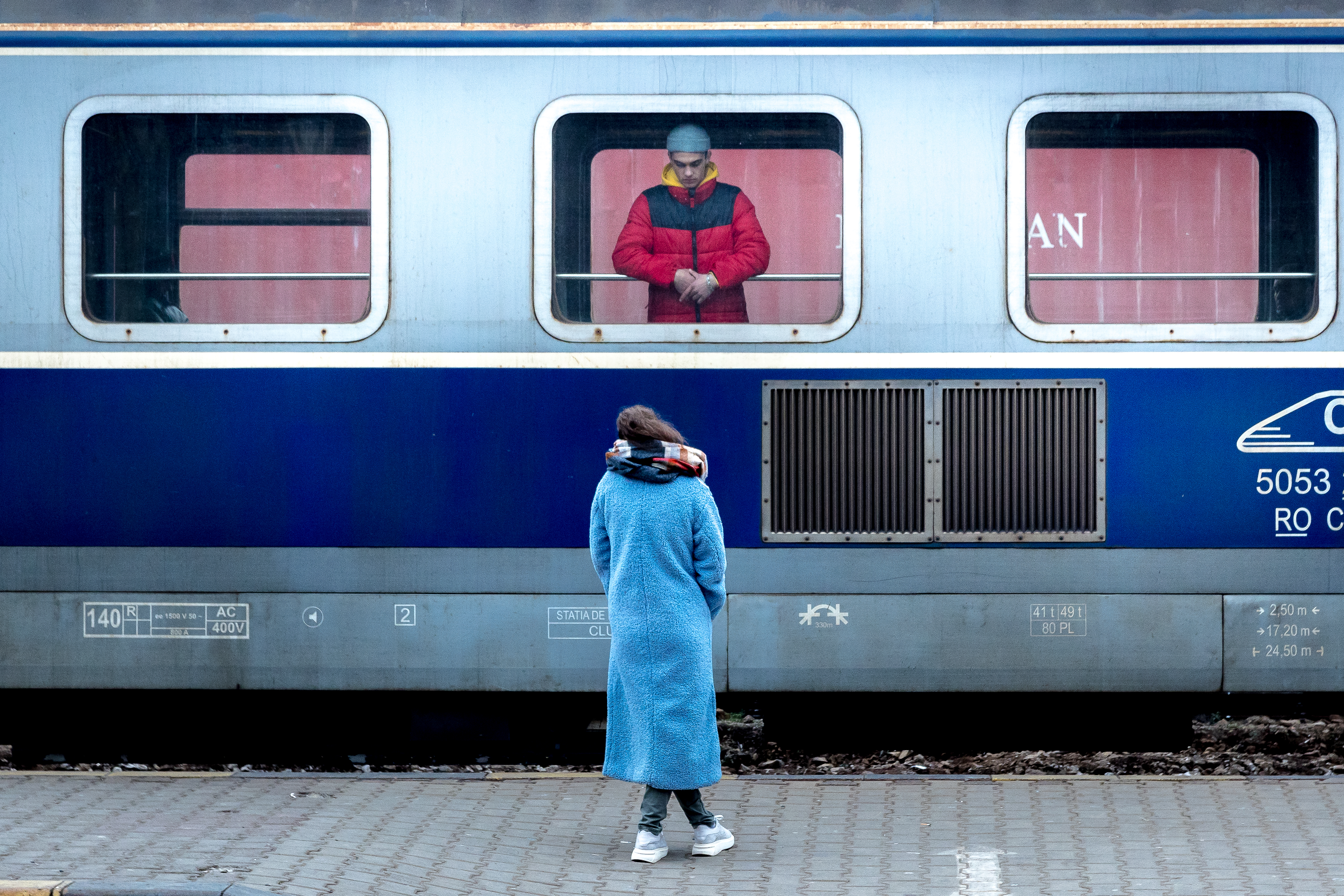 Two people say goodbye at a train station