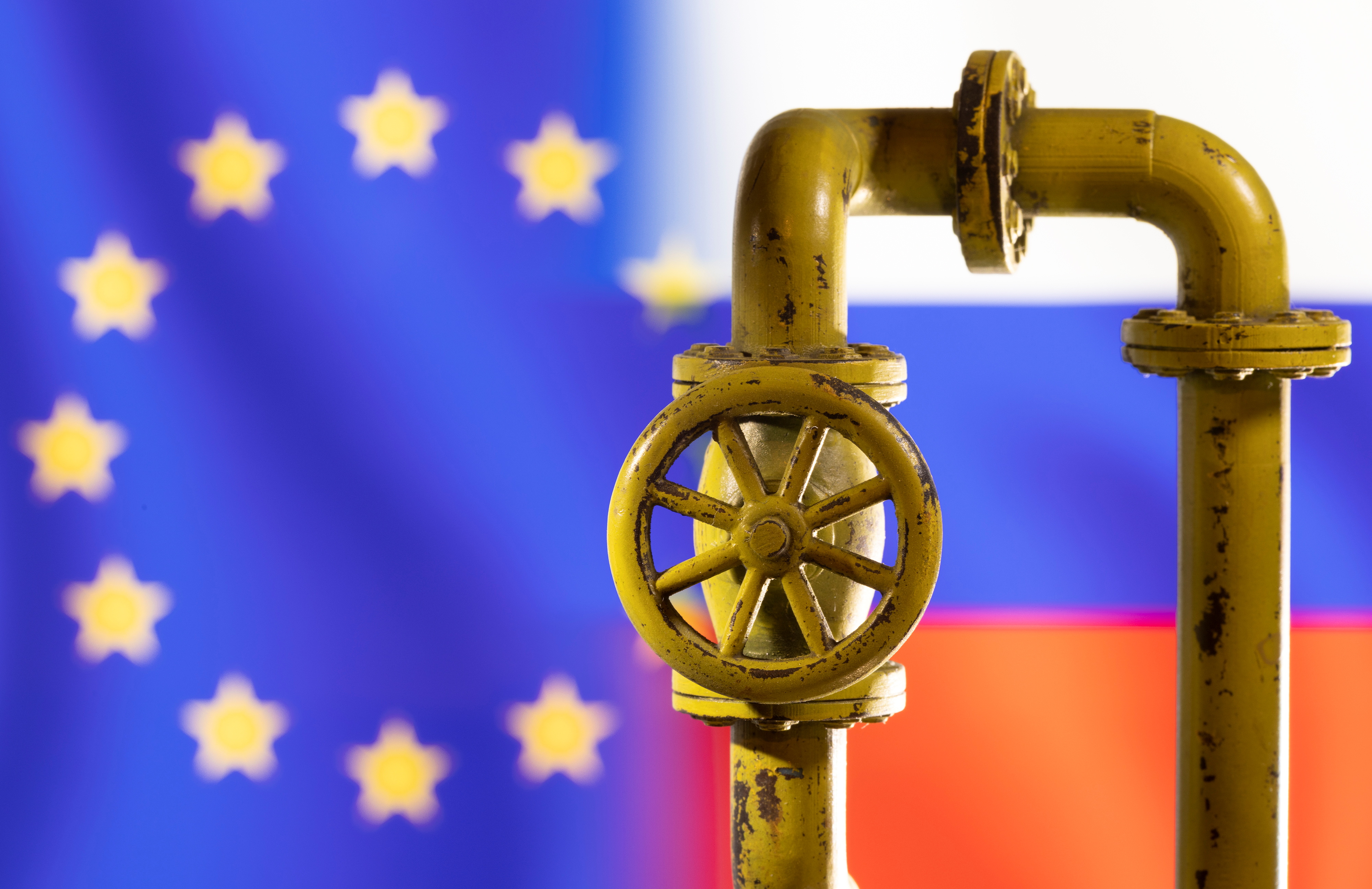 A model of the natural gas pipeline is seen in front of displayed word EU and Russia flag colours in this illustration