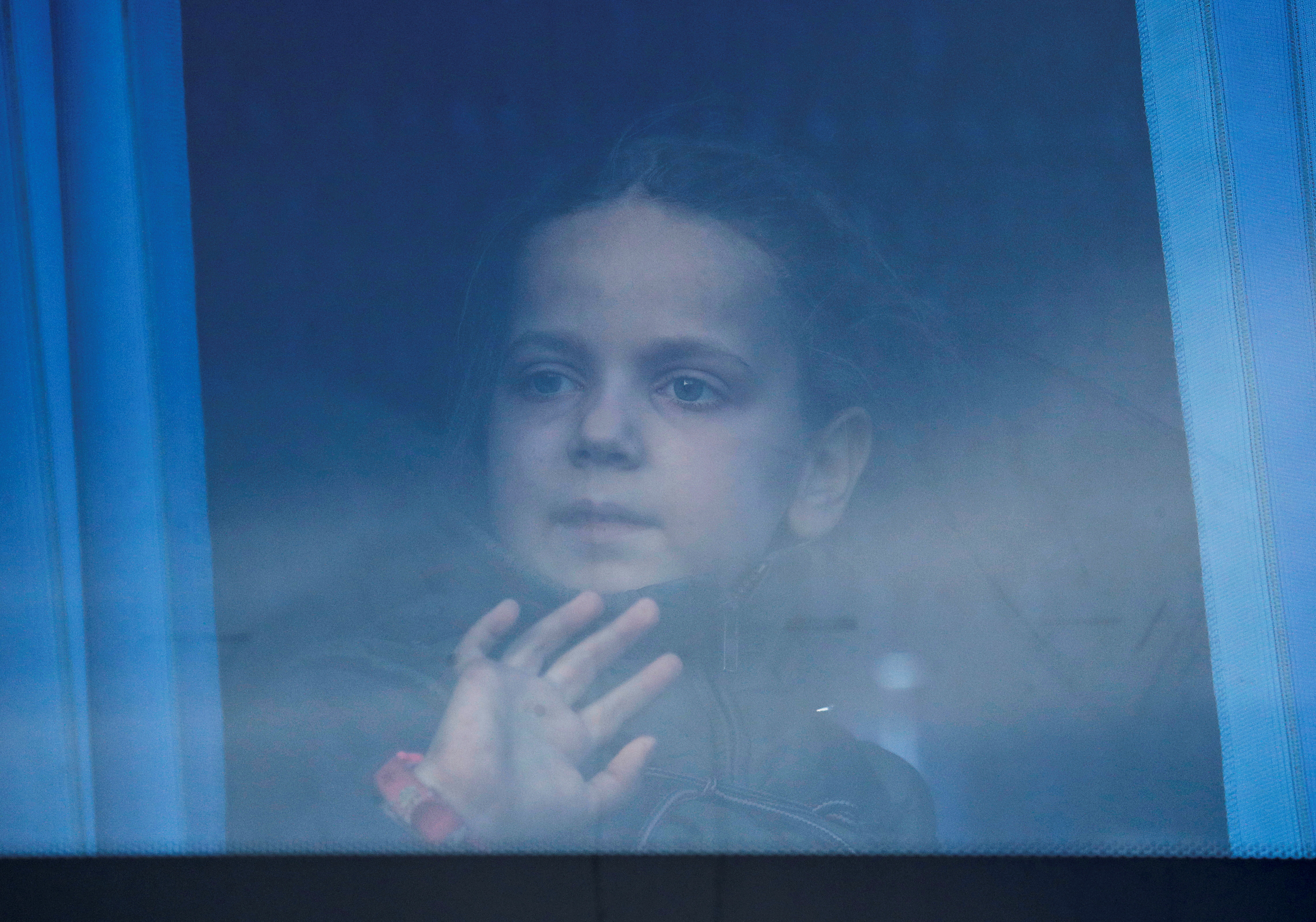 A girl looks through the bus window as civilians evacuated from Azovstal steel plant in Mariupol arrive at a temporary accommodation centre in the village of Bezimenne, during Ukraine-Russia conflict in the Donetsk Region, Ukraine May 6, 2022.