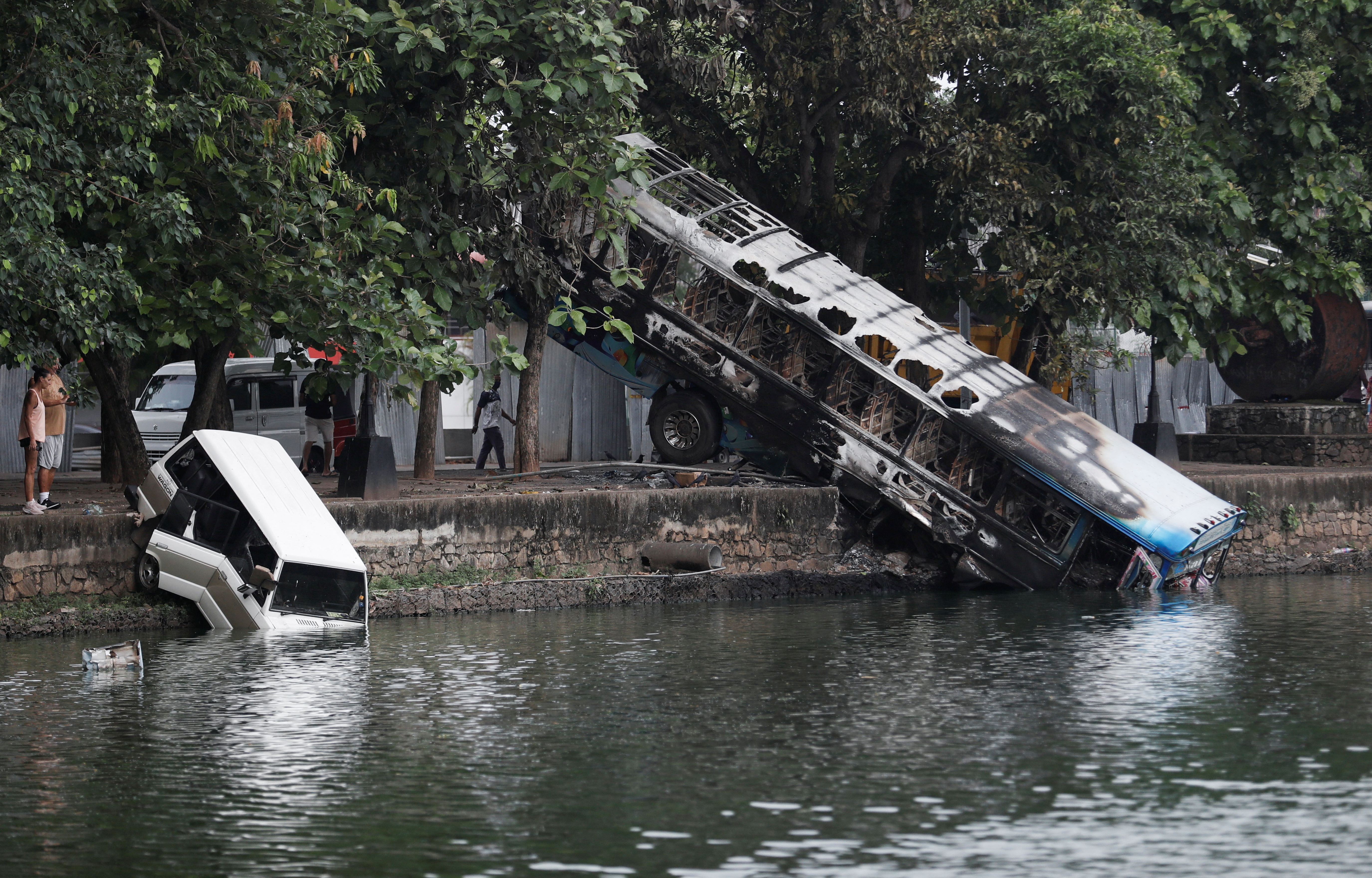 Vehicles of Sri Lanka's ruling party supporters are seen in a lake after being pushed into the water during a clash of pro and anti-government demonstrators near the Prime Minister's official residence