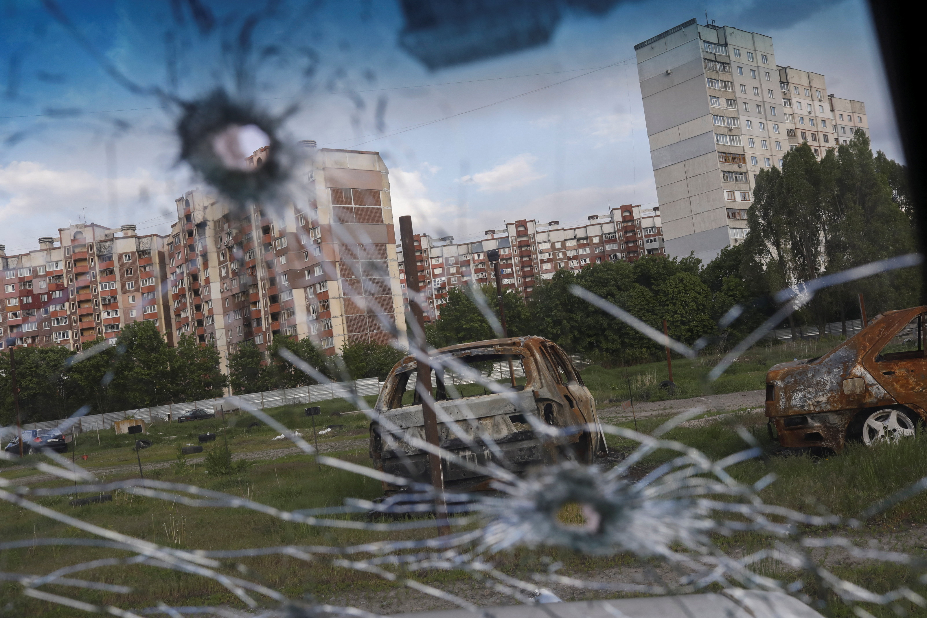Burnt cars and damaged buildings are seen in Kharkiv