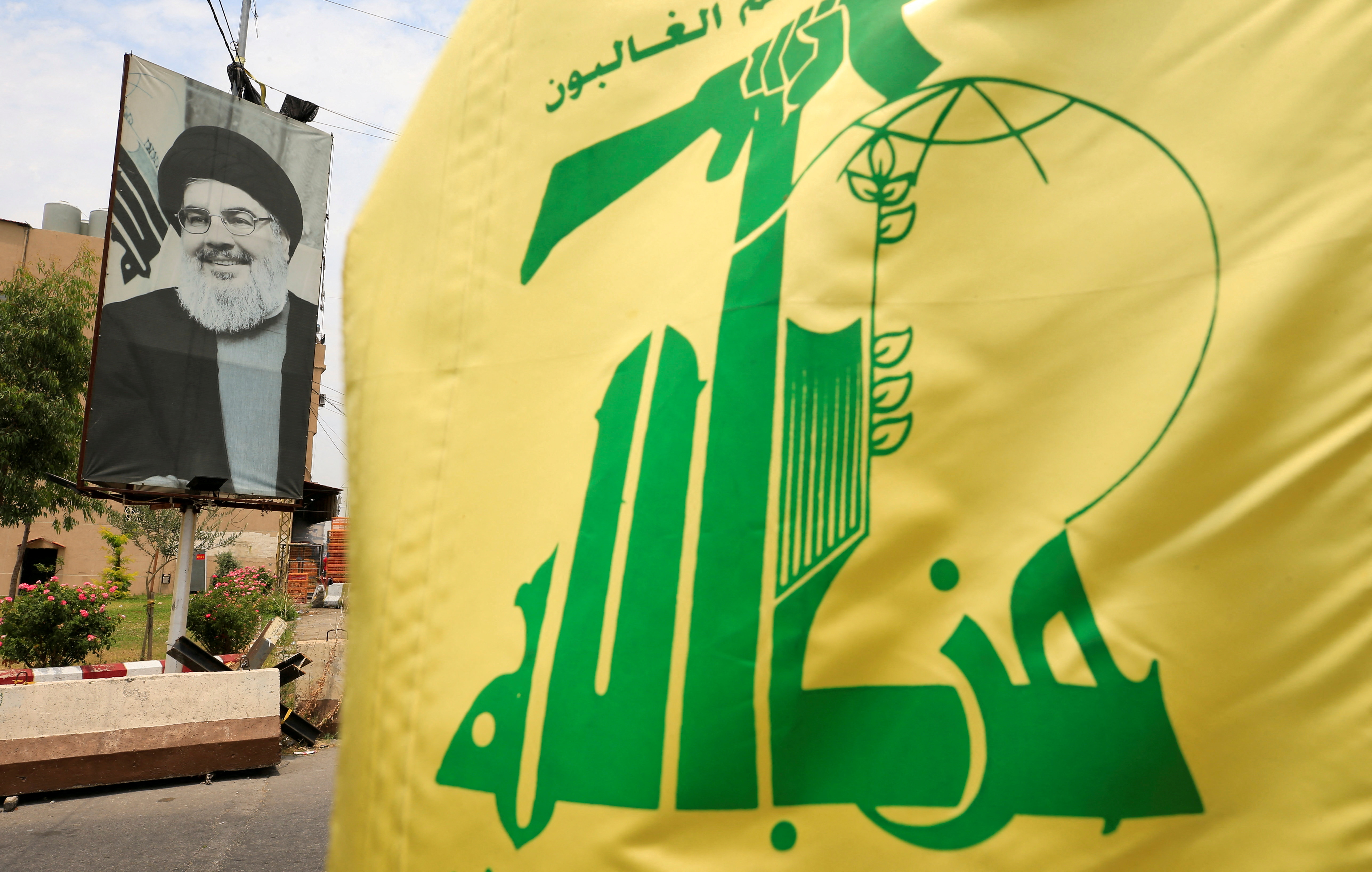 A Hezbollah flag and a poster depicting the group's leader Hassan Nasrallah
