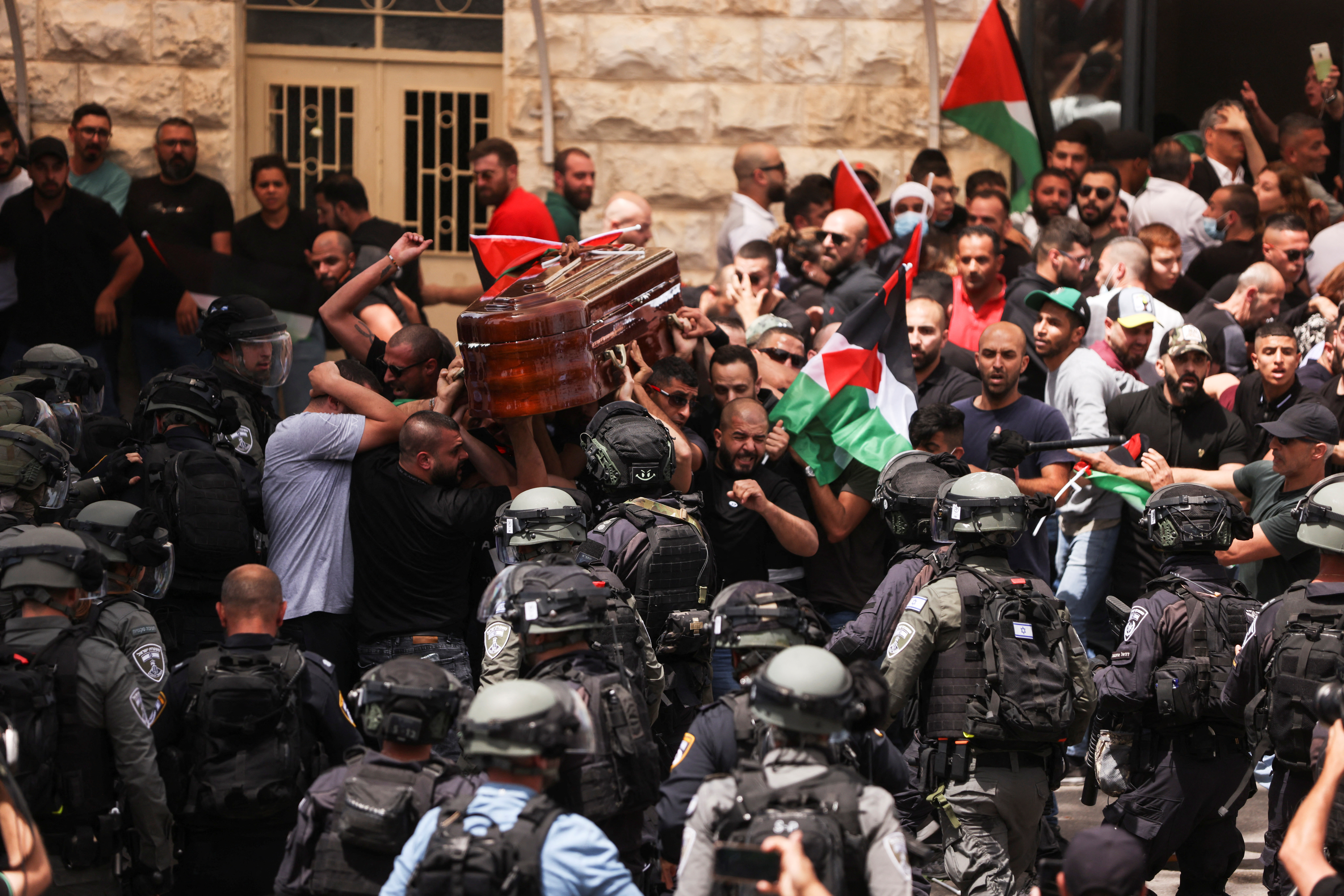 Family and friends carry the coffin of Al Jazeera reporter Shireen Abu Akleh, who was killed during an Israeli raid in Jenin in the occupied West Bank, as clashes erupted with Israeli security forces, during her funeral in Jerusalem