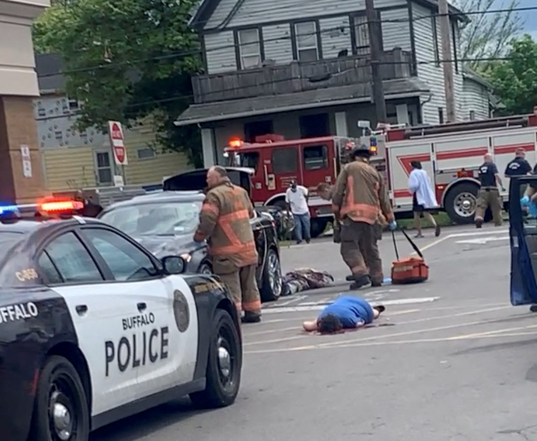 Injured people lie on the ground following a mass shooting in the parking lot of TOPS supermarket,