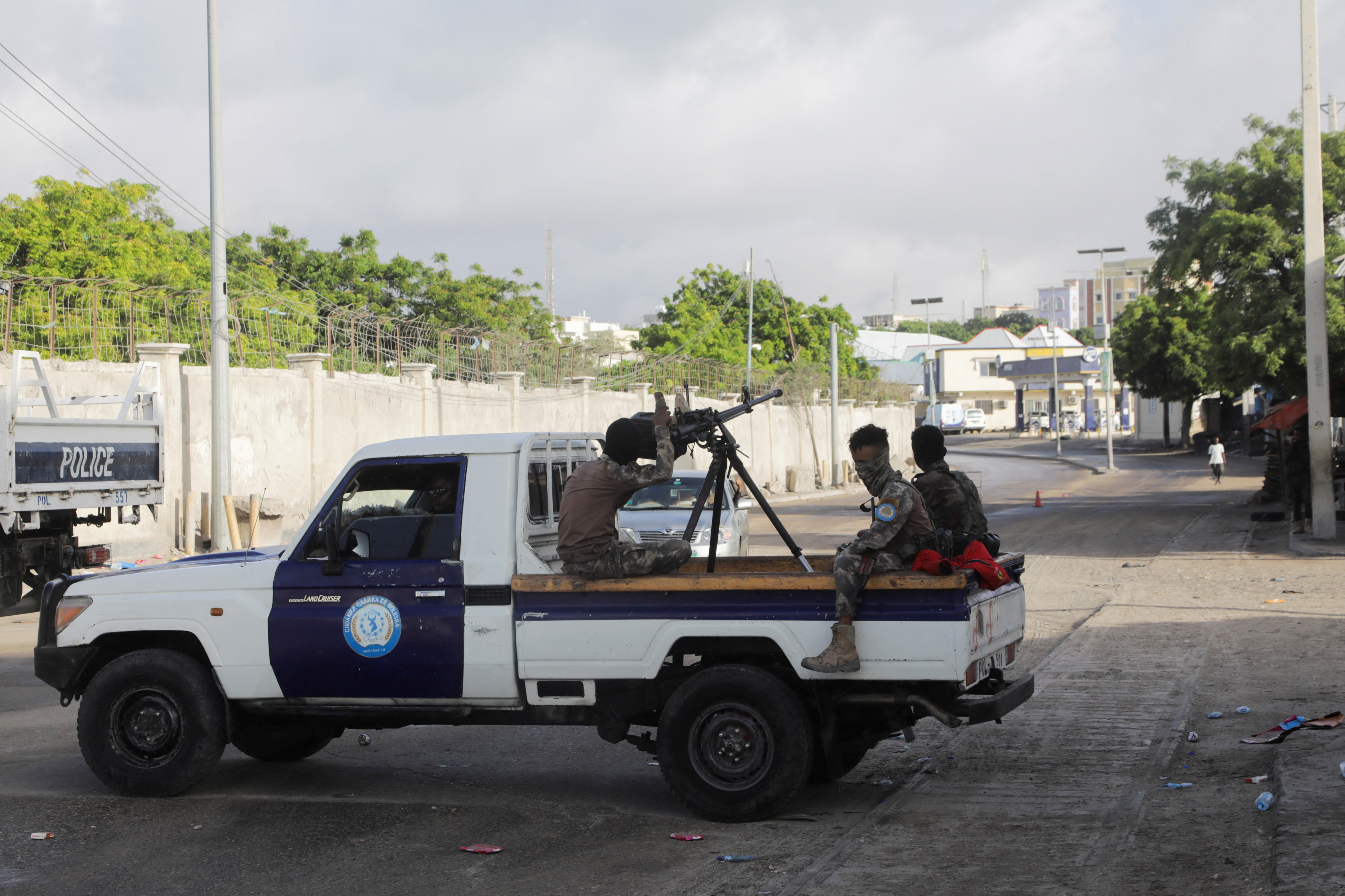 Somali policemen sit on a pickup truck as they enforce a curfew