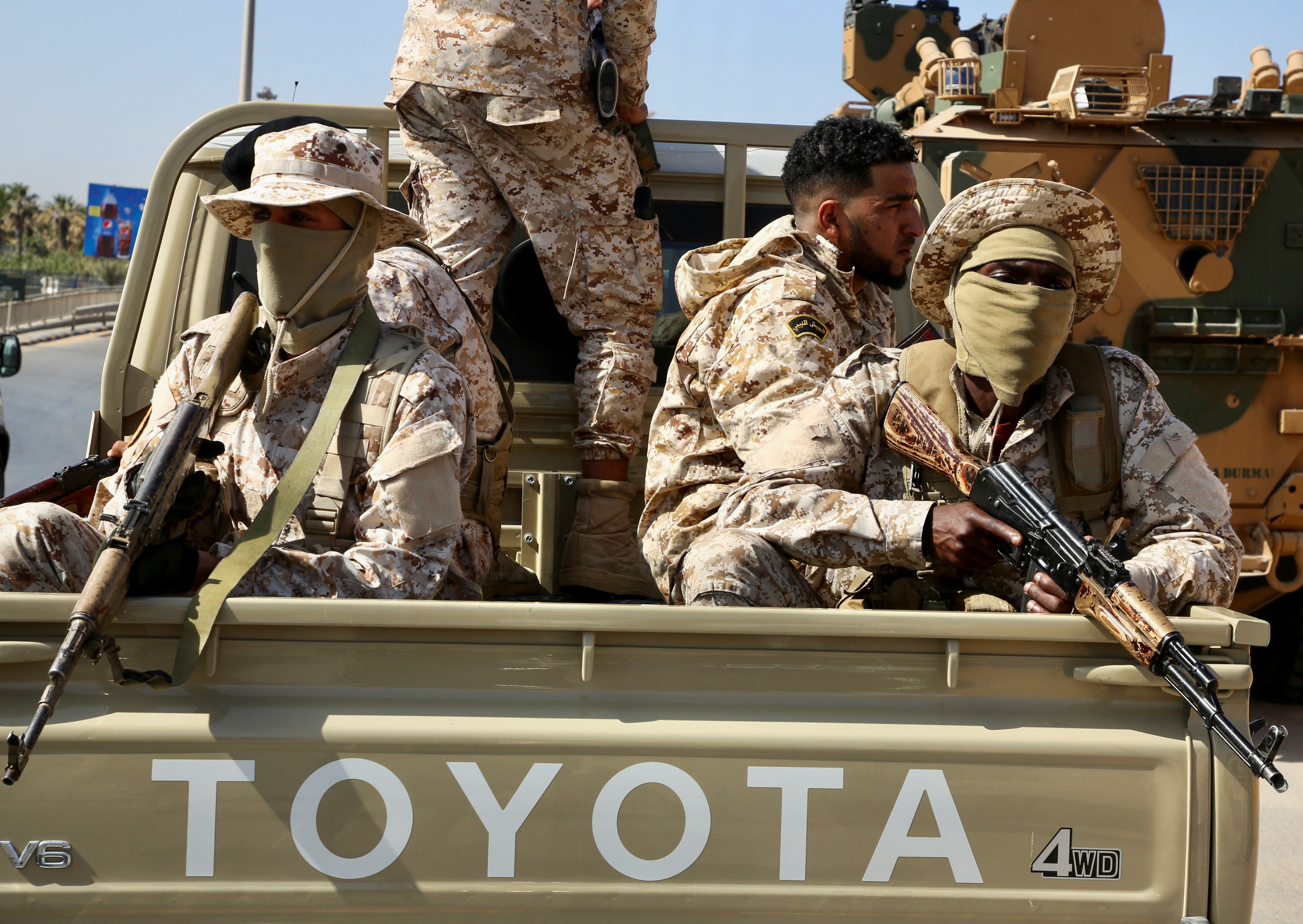 Soldiers loyal to the head of Libya's Government of National Unity, Abdulhamid al-Dbeibah, sit in the back of a truck in Tripoli, Libya