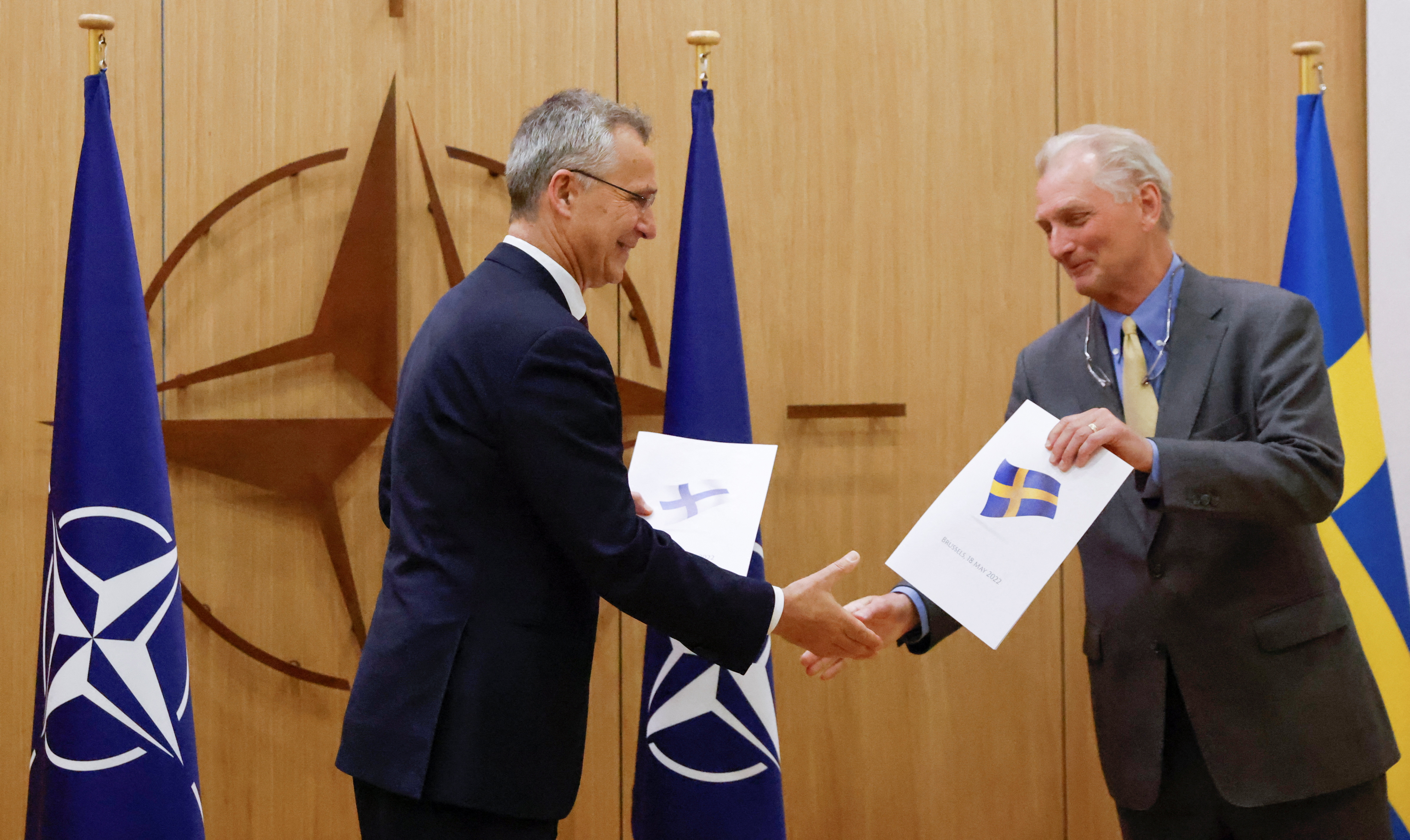 NATO Secretary-General Jens Stoltenberg and Sweden's Ambassador to NATO Axel Wernhoff shake hands during a ceremony to mark Sweden's and Finland's application for membership in Brussels, Belgium.