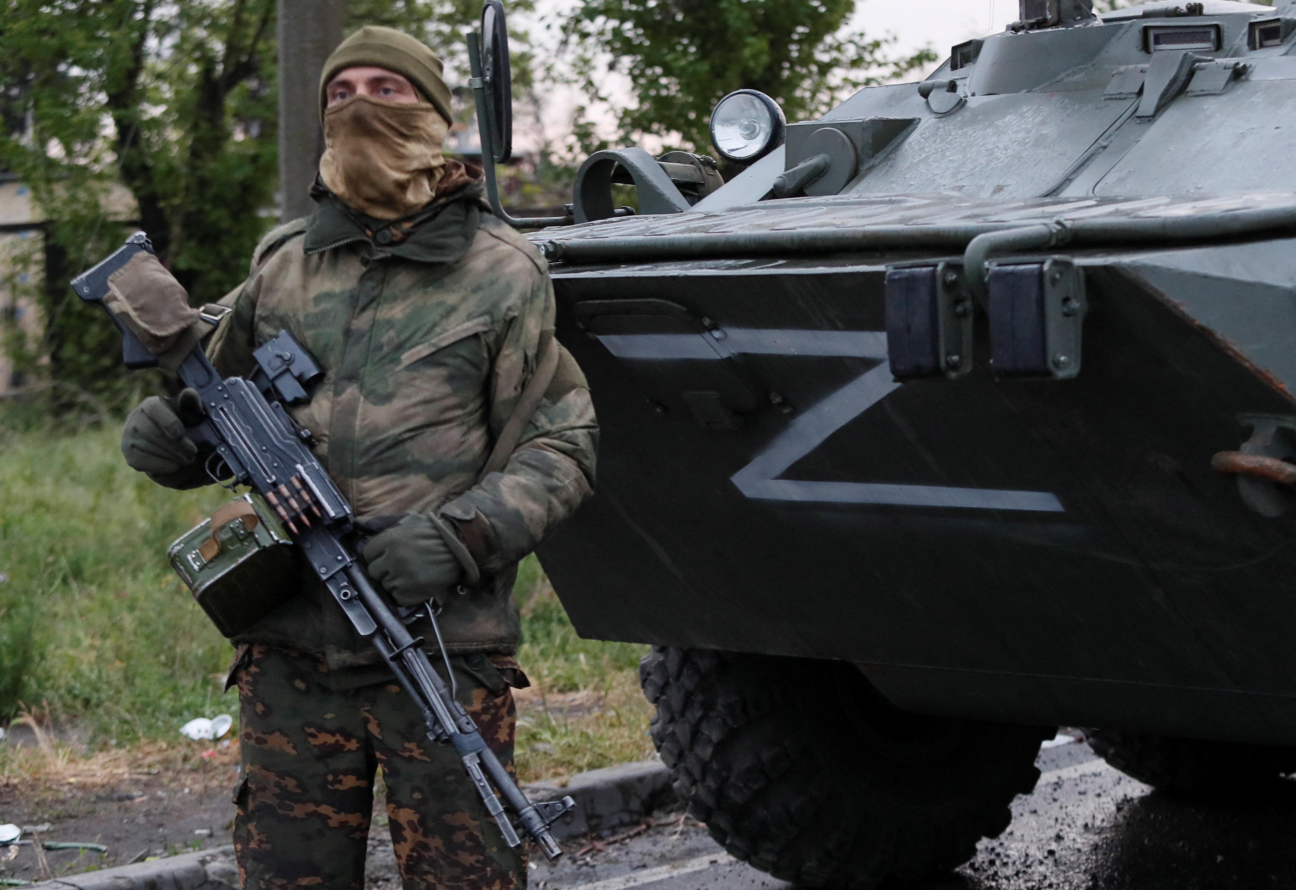 A service member of pro-Russian troops stands guard before the expected departure of Ukrainian soldiers, who surrendered at the besieged Azovstal steel mill, in the course of Ukraine-Russia conflict in Mariupol, Ukraine May 19
