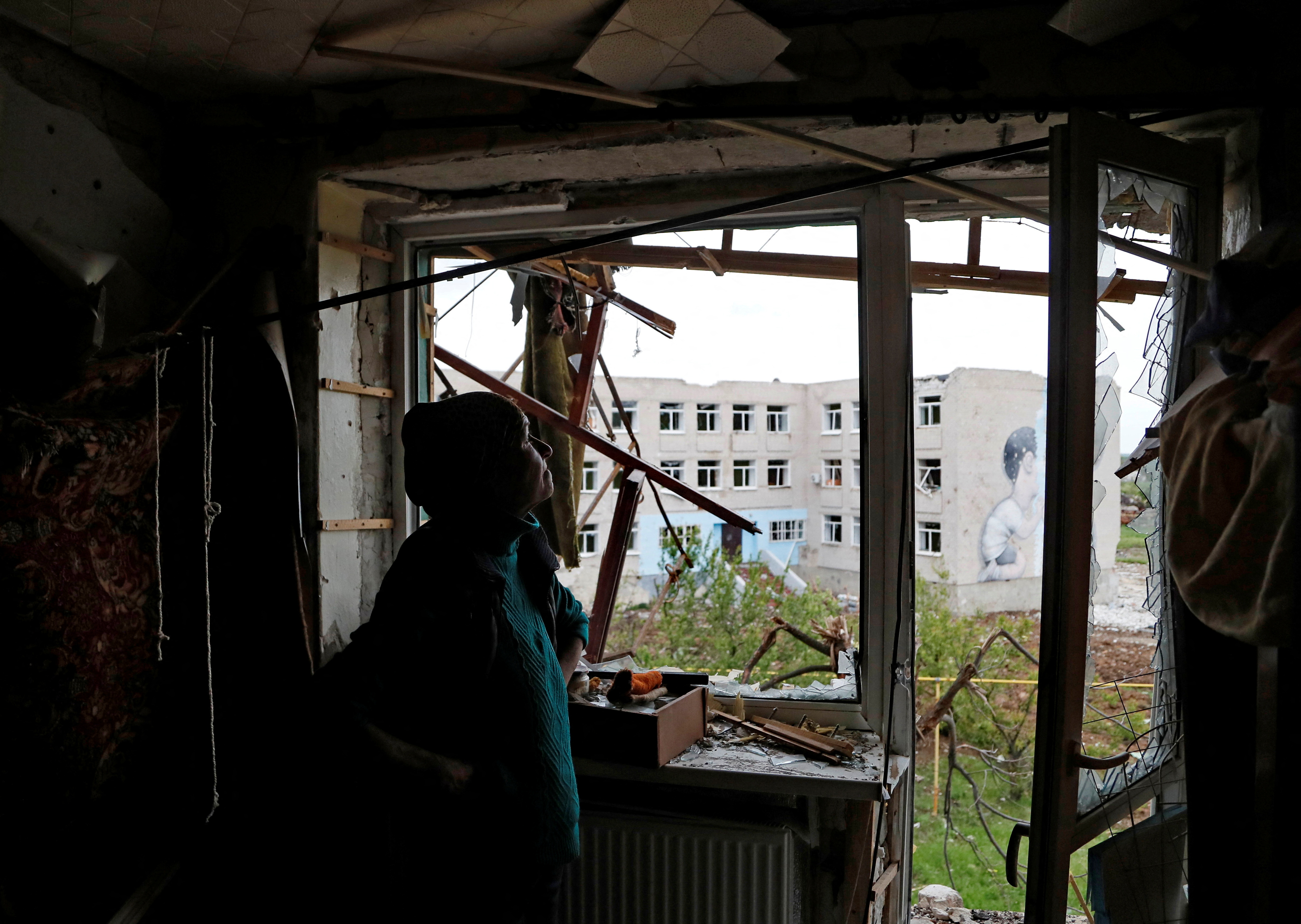 Local resident Natalia Kovalenko, 52, stands inside her apartment damaged during Ukraine-Russia conflict in the town of Popasna in the Luhansk Region, Ukraine May 26, 2022. REUTERS/Alexander Ermochenko