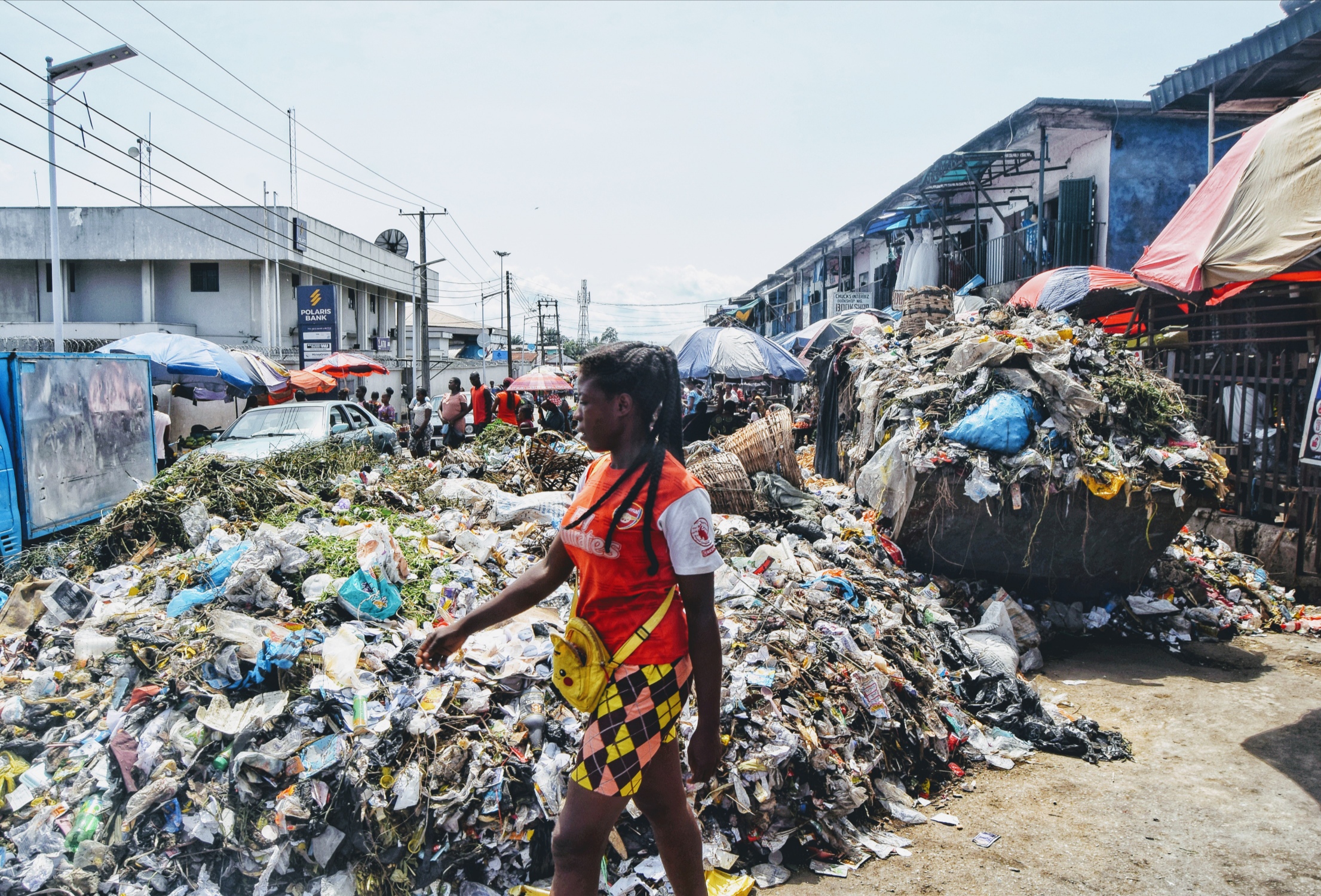 A woman walks beside the overflowing refuse dump at Watts Market in Calabar, southern Nigeria