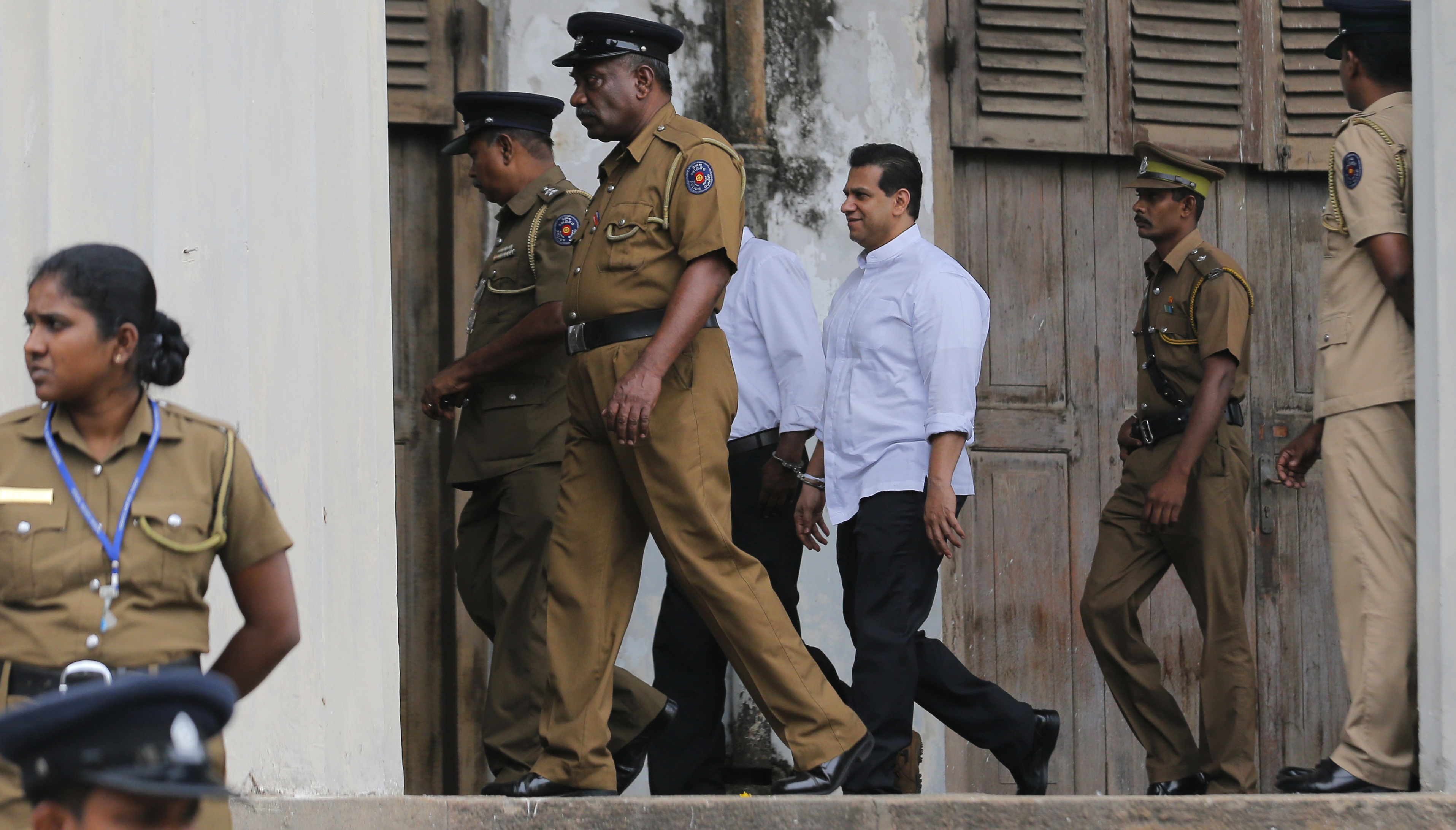 Sri Lankan police and prison officers escort former lawmaker Duminda Silva in Colombo.