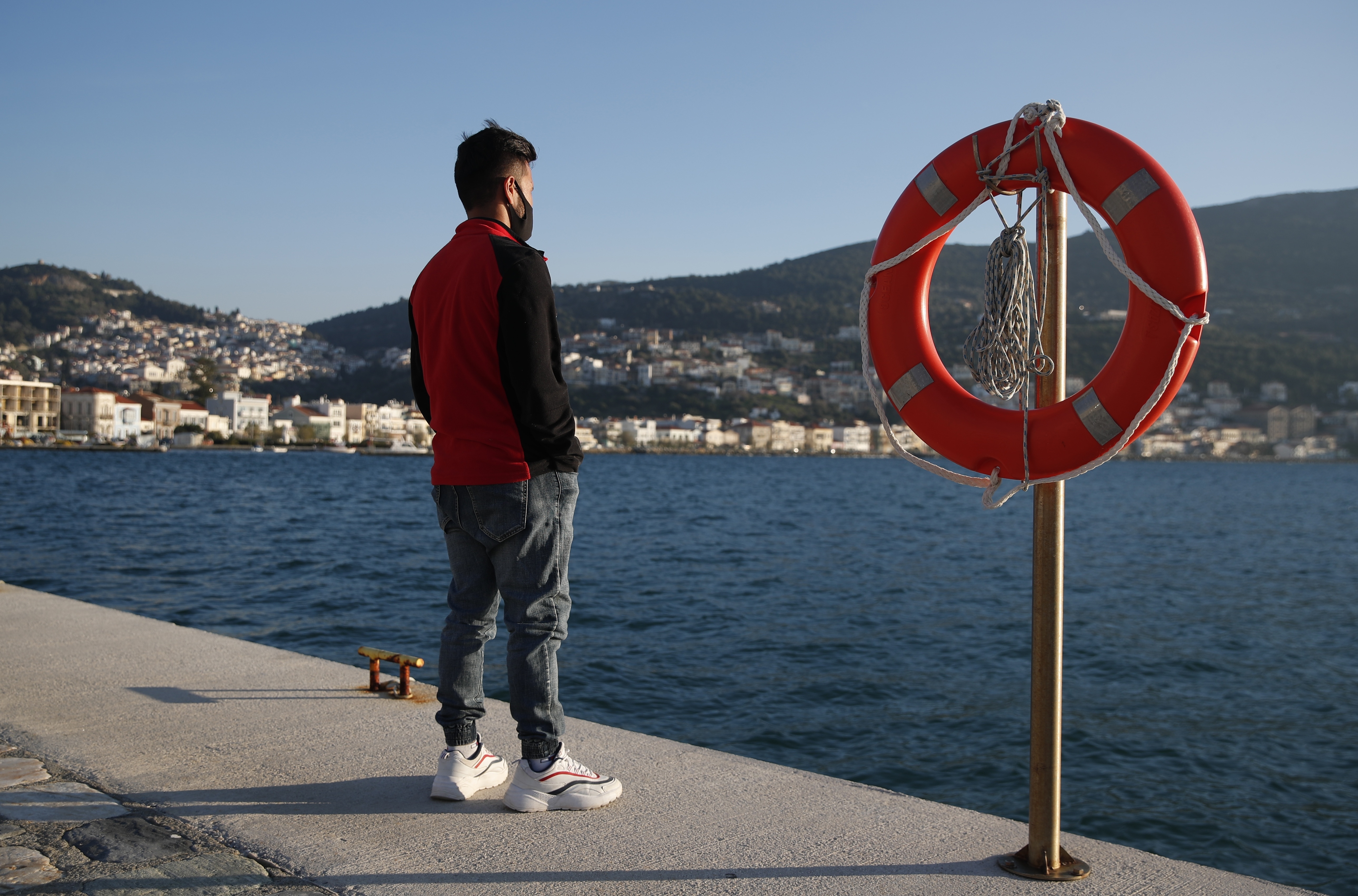 An Afghan father stands at the port of Vathy on the eastern Aegean island of Samos