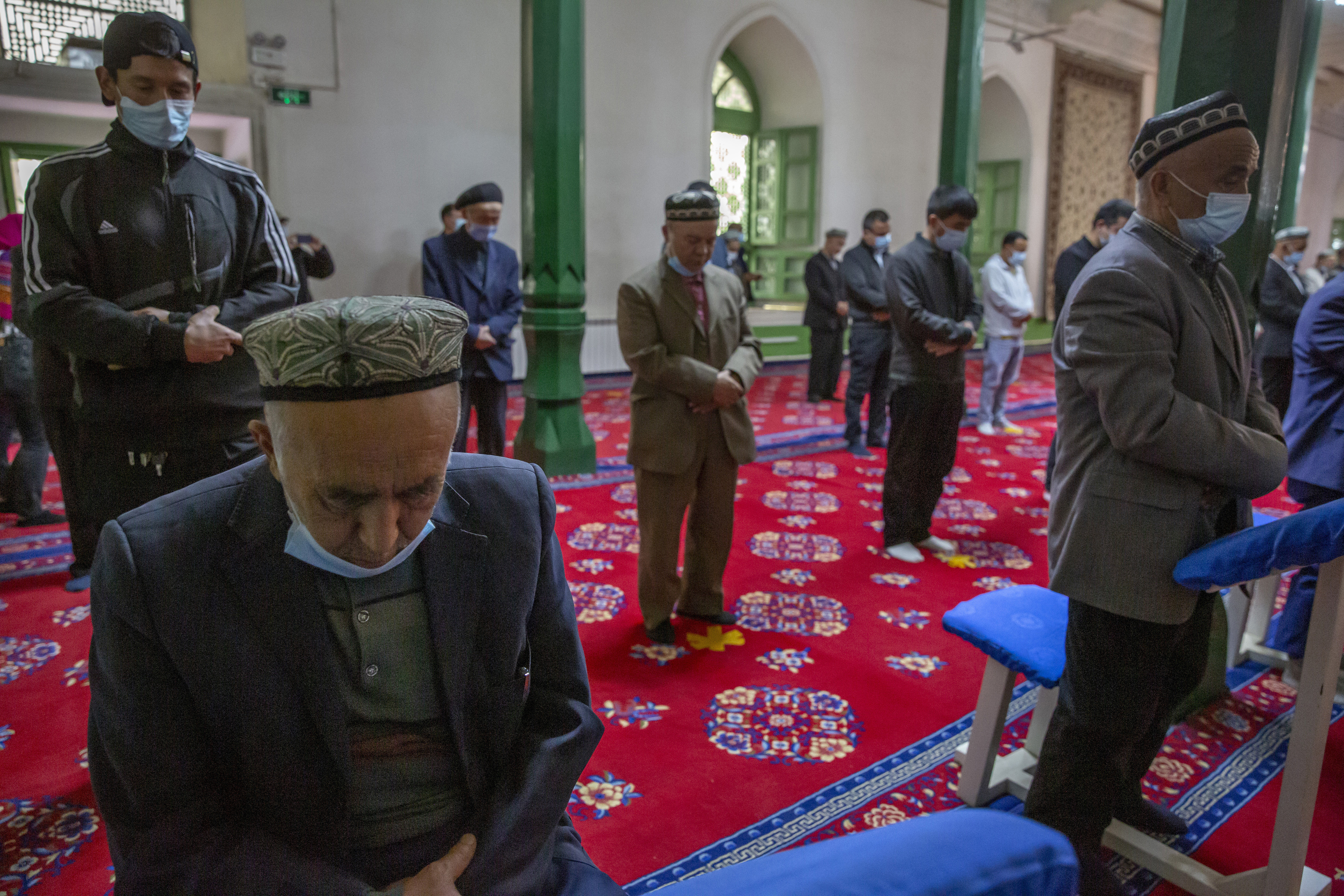 Uyghurs and other members of the faithful pray during services at the Id Kah Mosque in Kashgar in far west China's Xinjiang region, as seen during a government organized visit for foreign journalists on April 19, 2021.