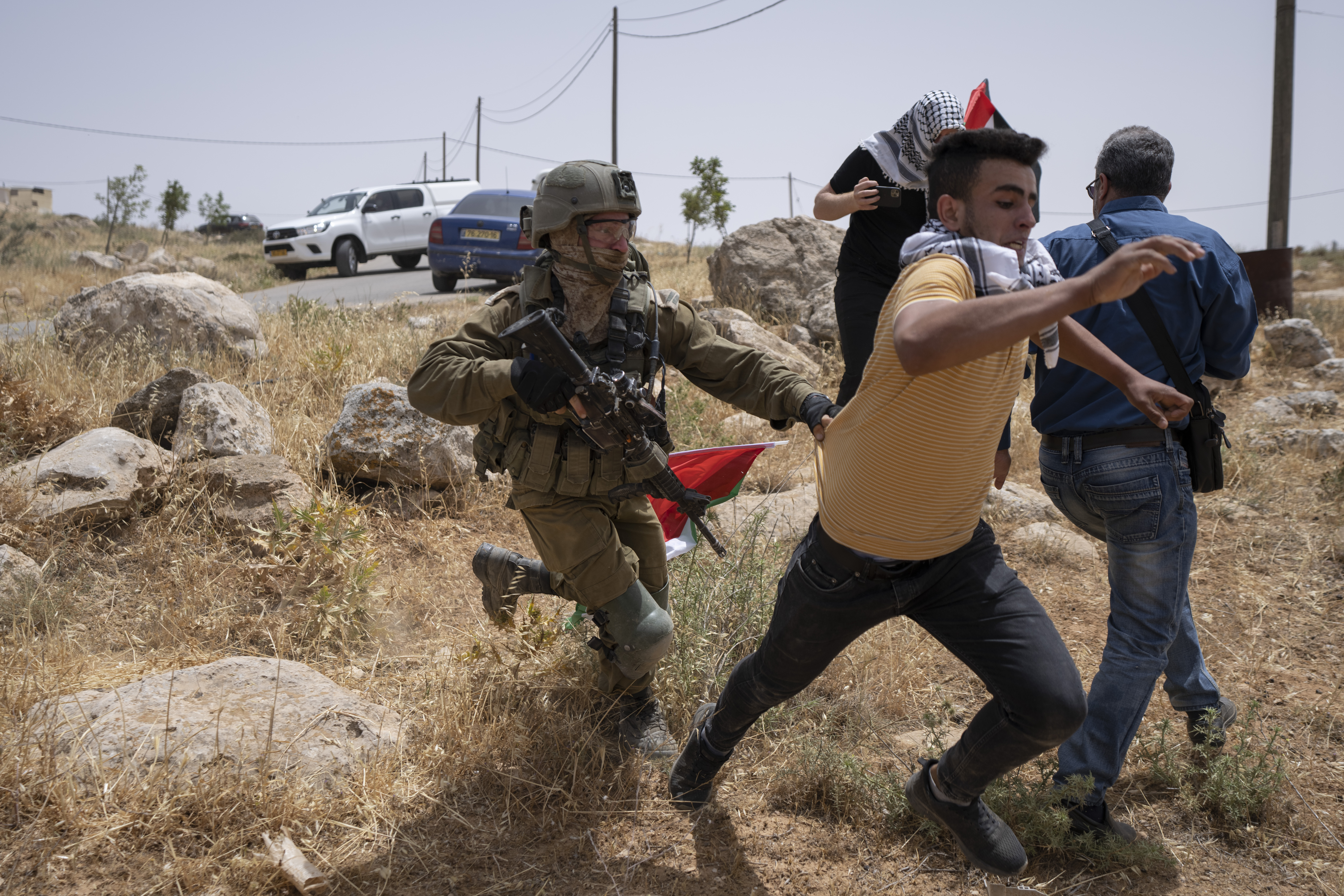 An Israeli soldier chases a protester