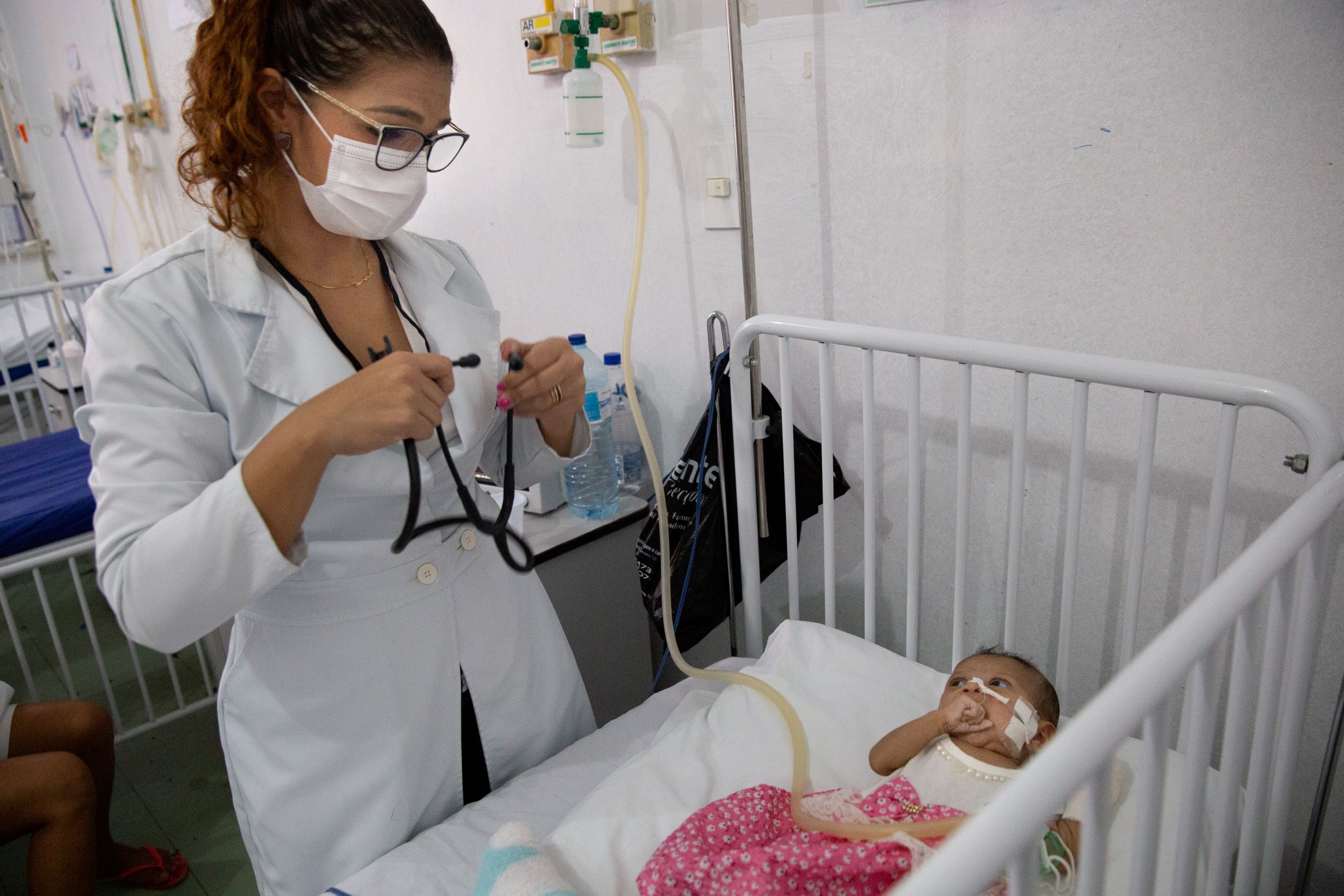 Dr Carla Carvalho pulls out her stethoscope to check the heart rate of one of her patients in Macapa, Brazil