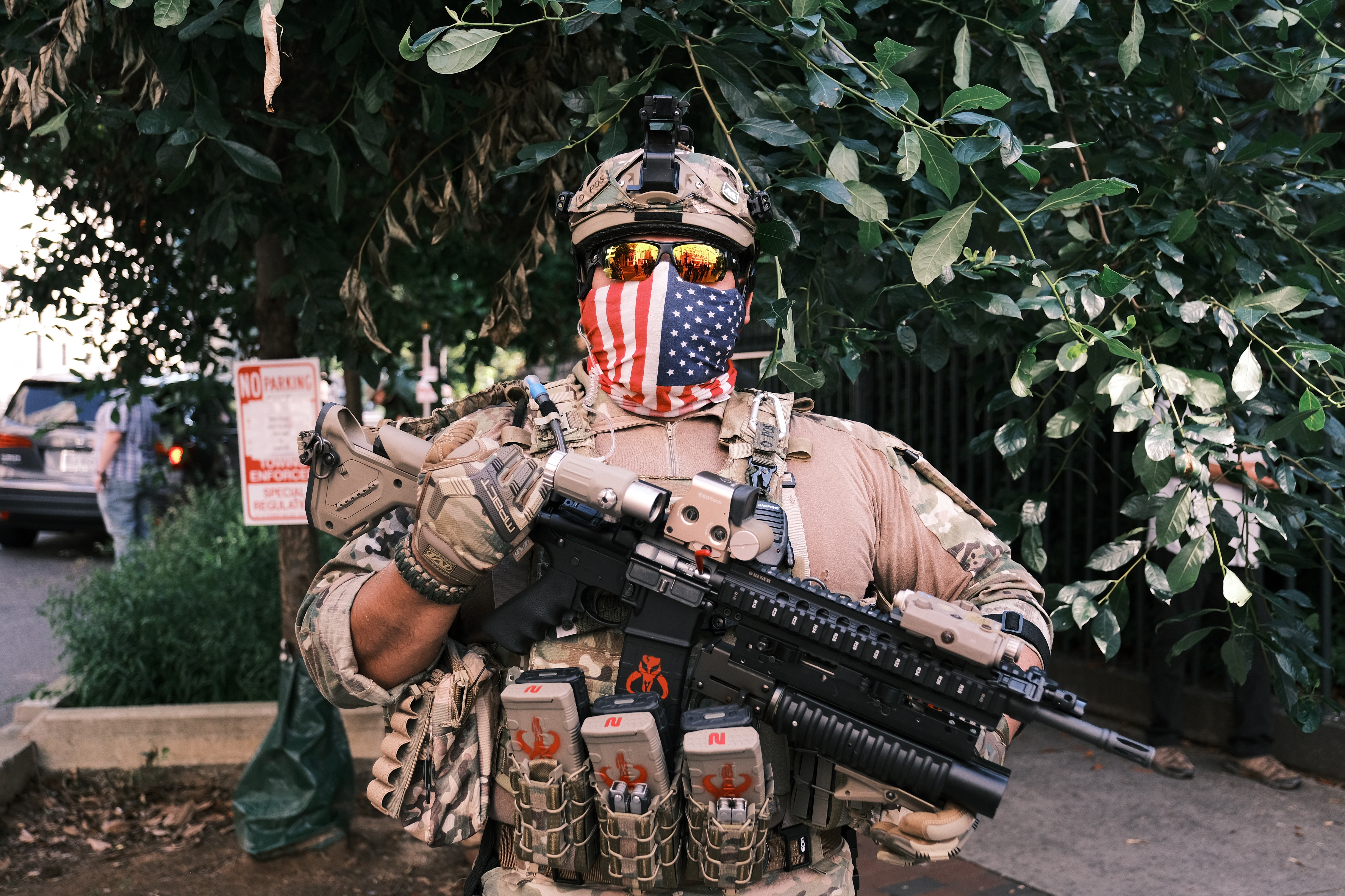 A man in full military gear pose for photo holding a gun