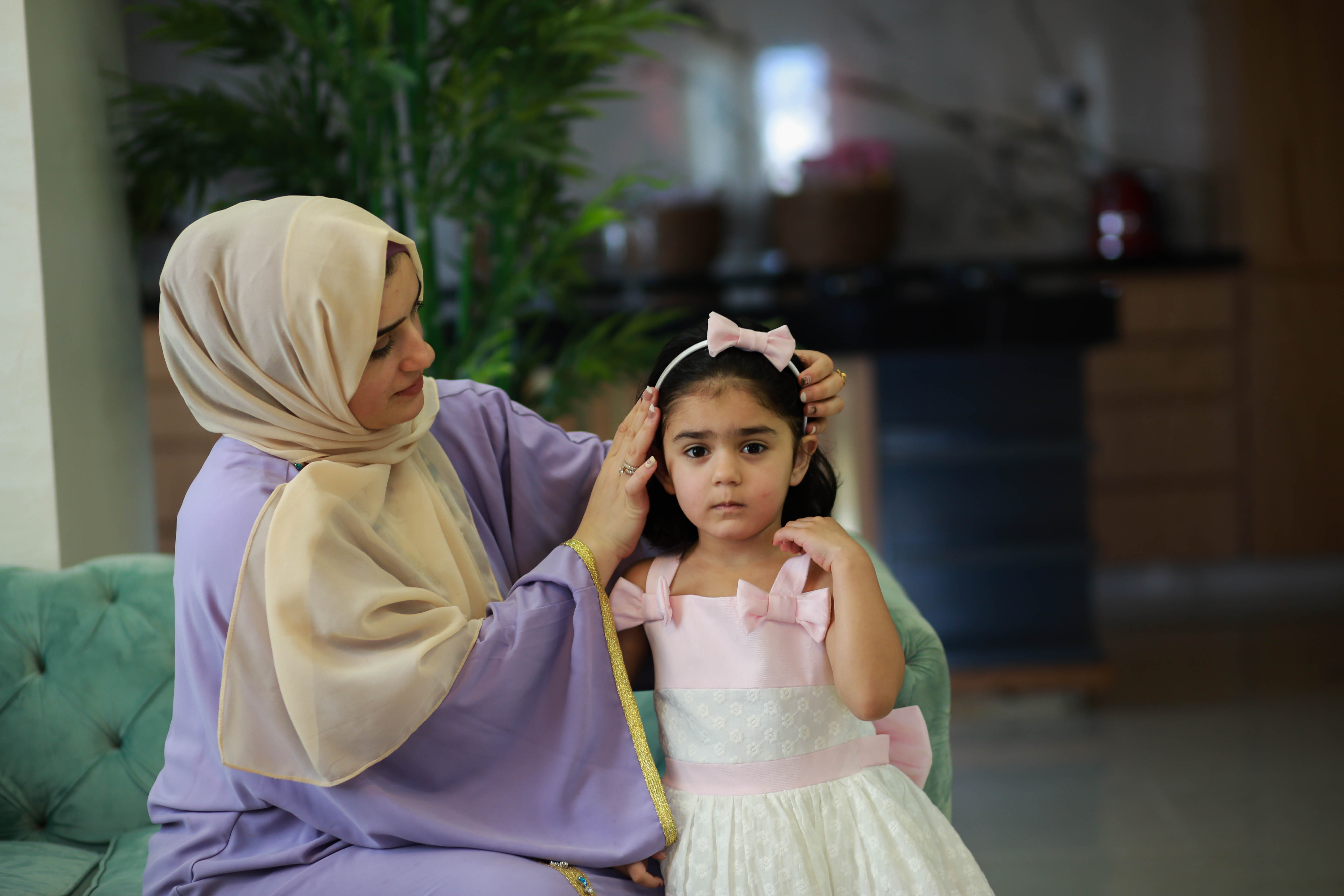 A mother dresses her daughter up.