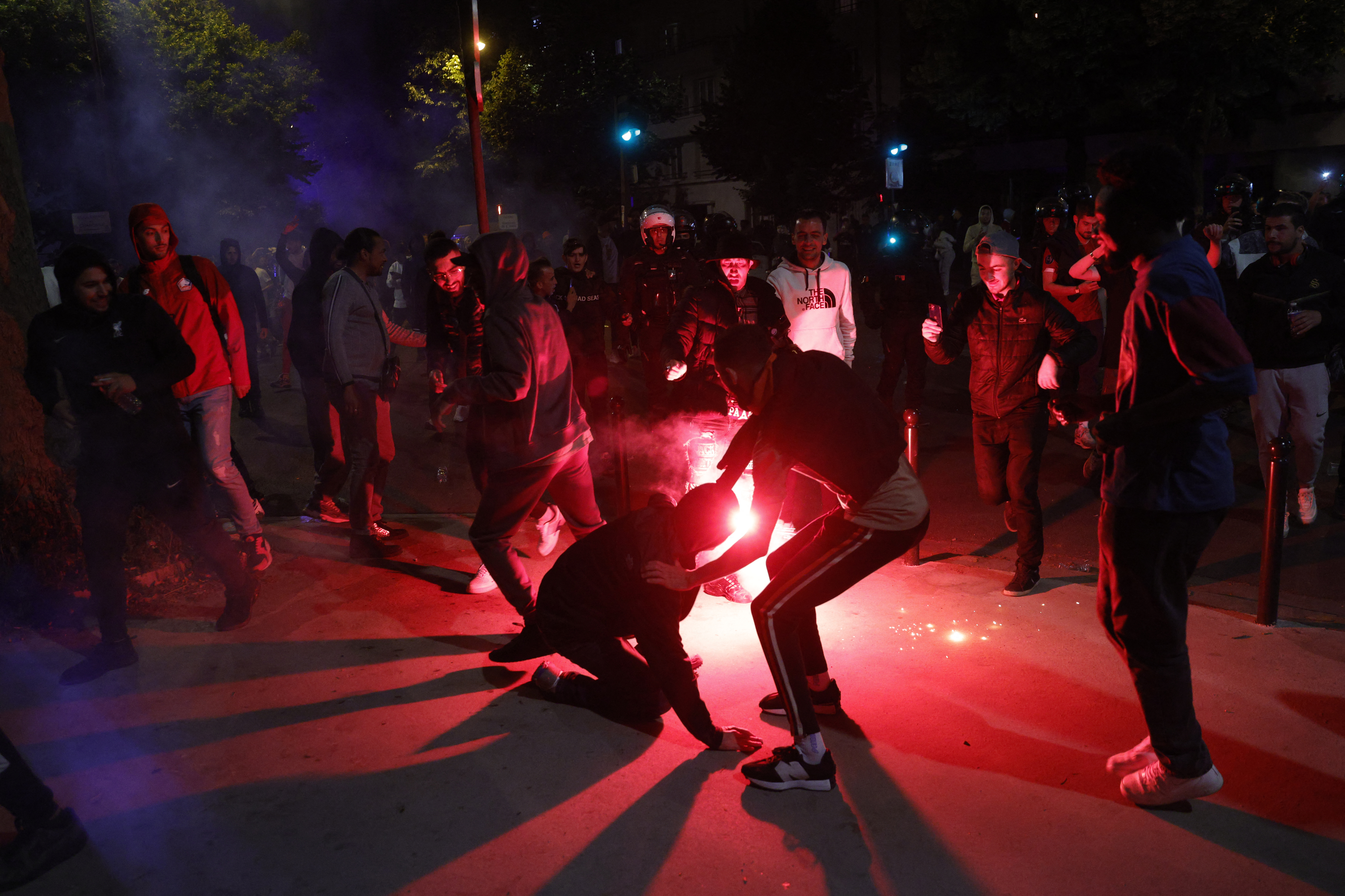 A Liverpool FC's supporter holds a flare near Place de la Nation in Paris.