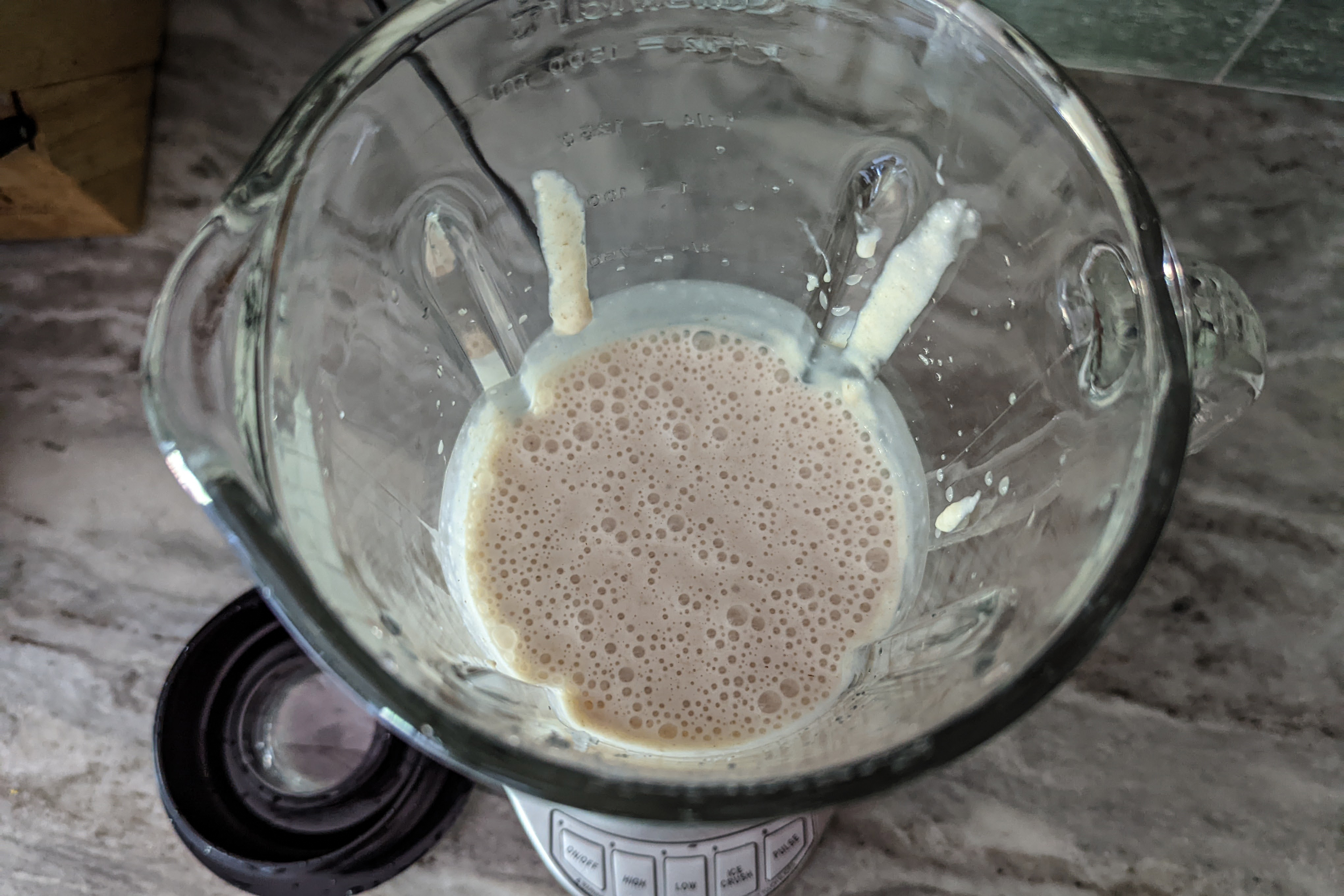 A view inside a glass belnder cup slightly spattered with pureed oatmeal