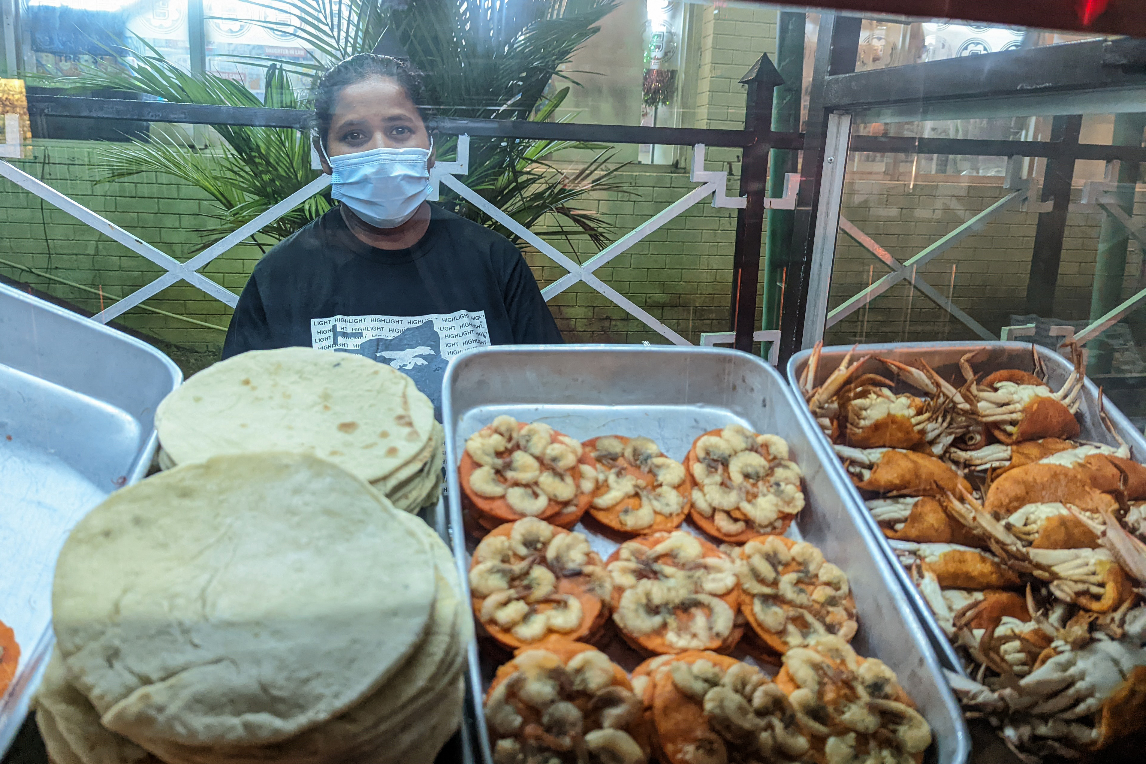 Street vendor stands behind her food stall