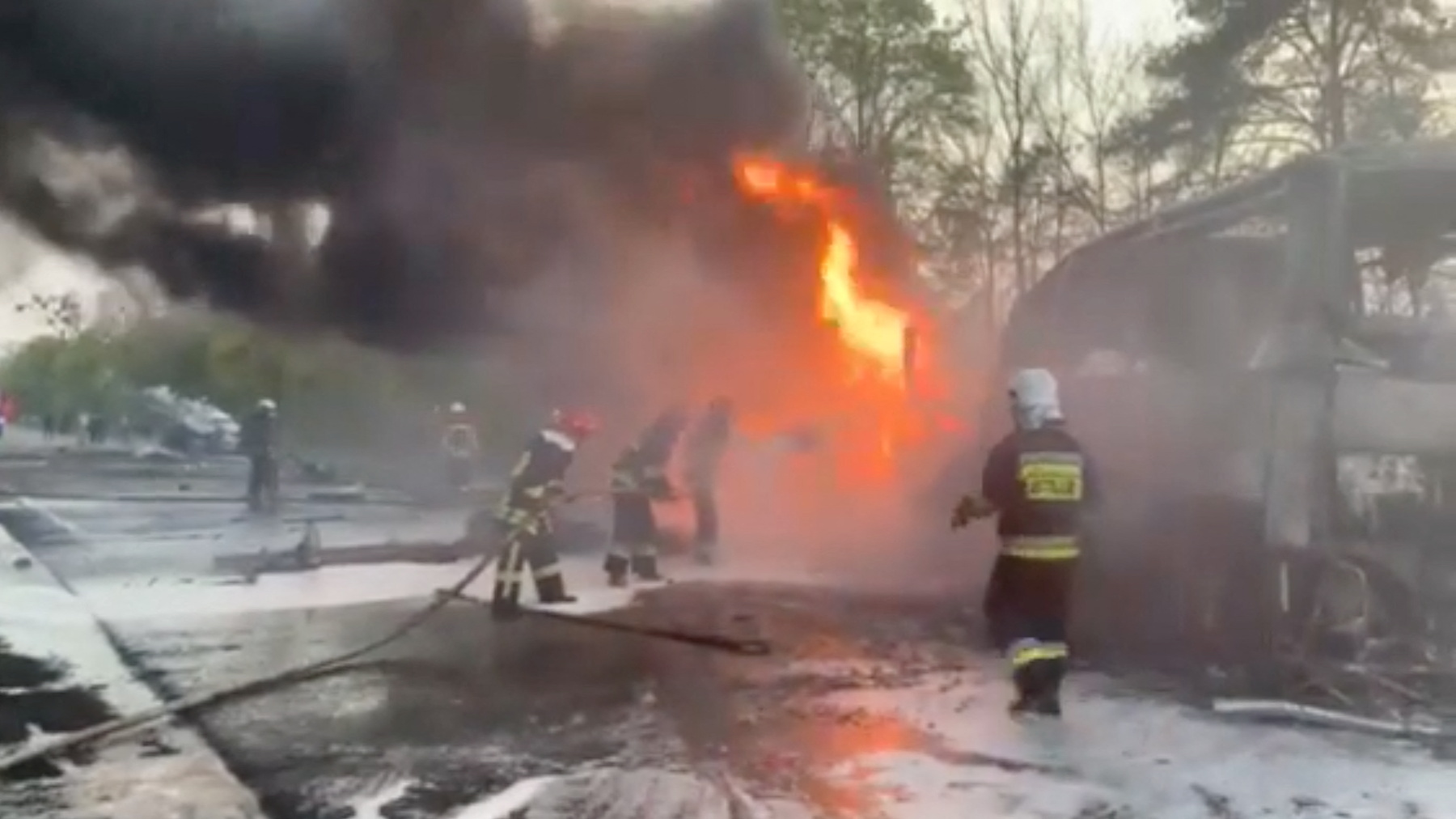 Firefighters spray water onto a vehicle after a fuel truck collided with a bus on the Kyiv-Chop highway in Sitne, Dubna district, Rivne region 