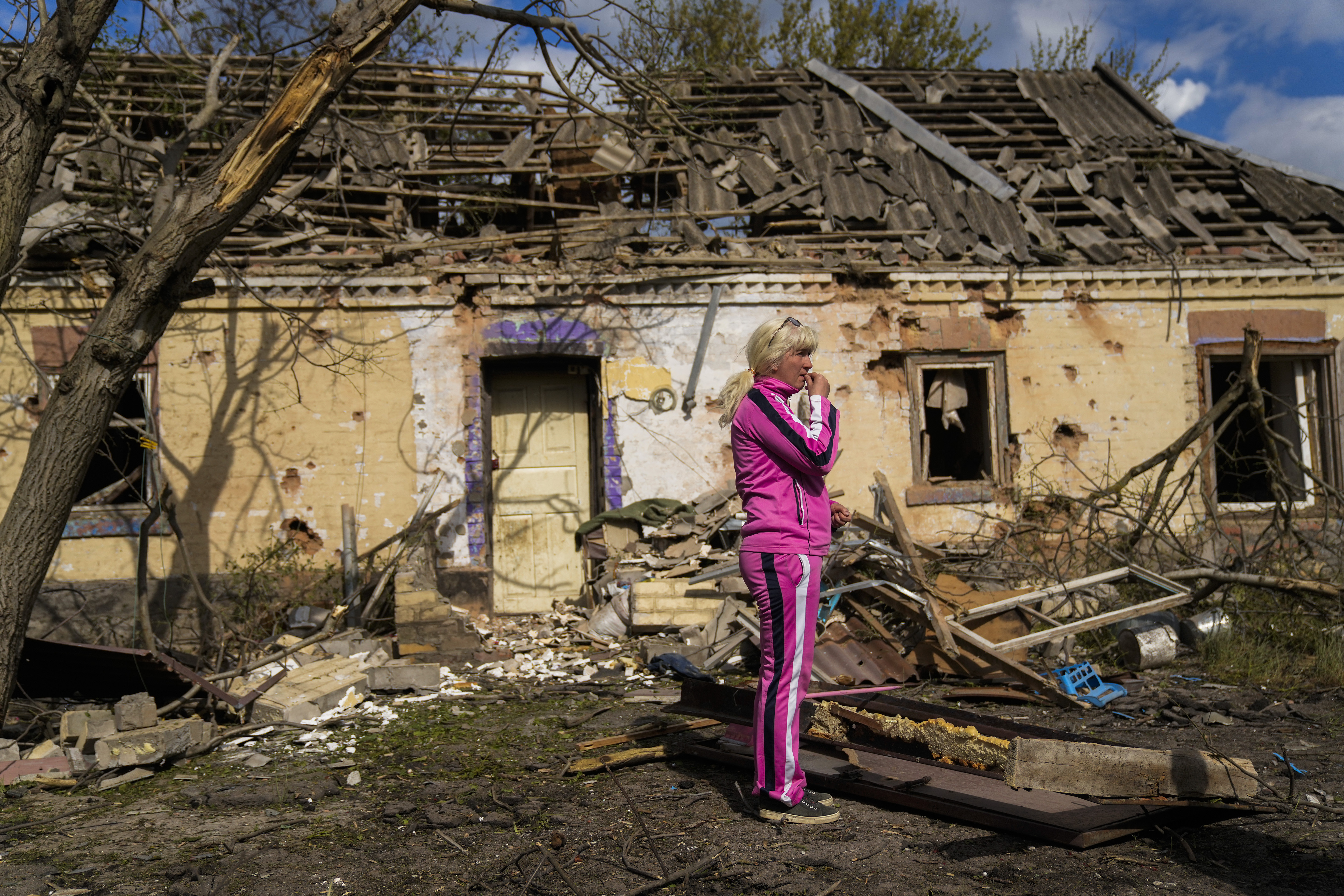 Iryna Martsyniuk, 50, stands next to her house, heavily damaged after a Russian bombing in Velyka Kostromka village, Ukraine.