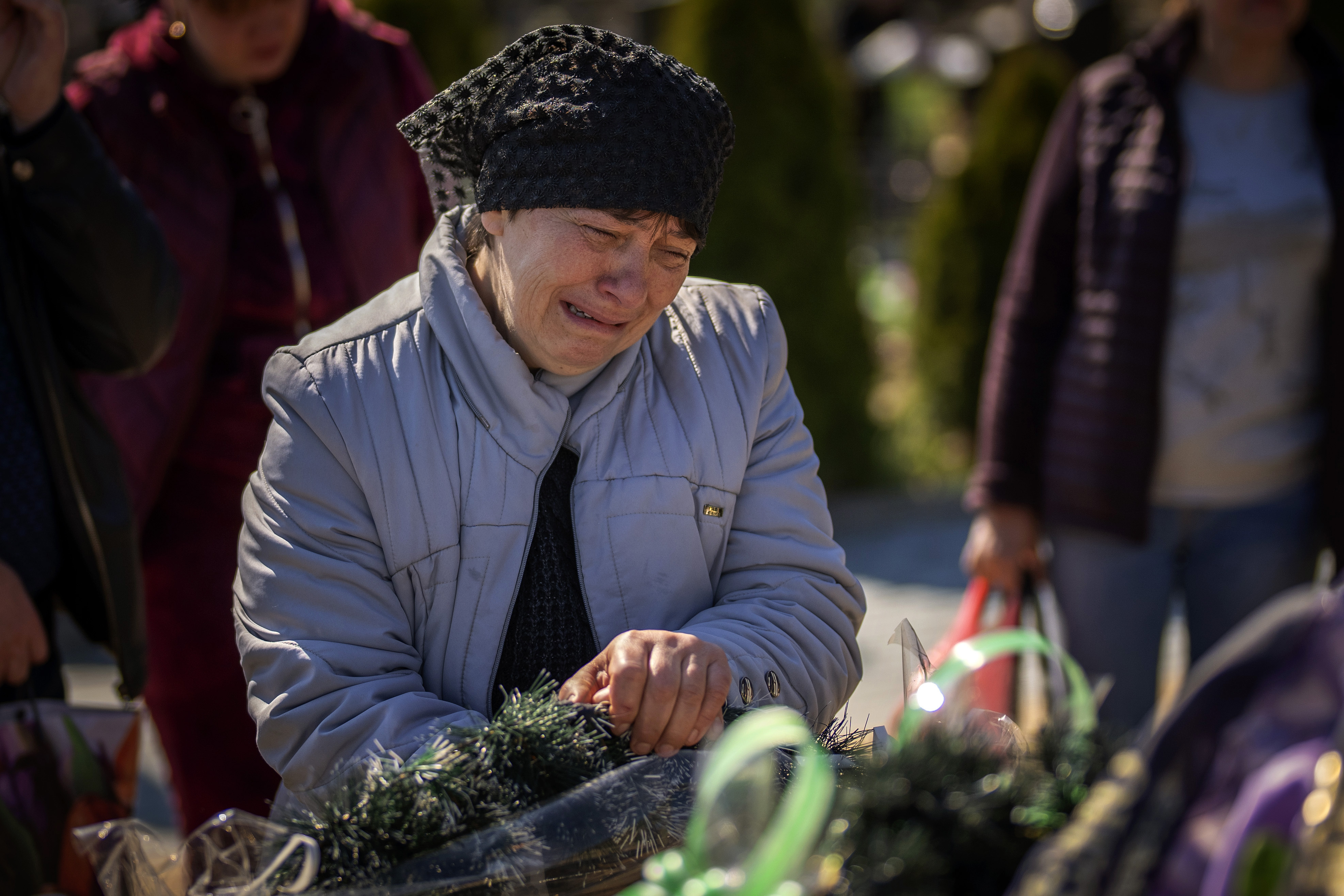 The mother of Oleksandr Mozheiko, 31, an Irpin Territorial Defense soldier killed by the Russian army, cries at his grave at the cemetery of Irpin.