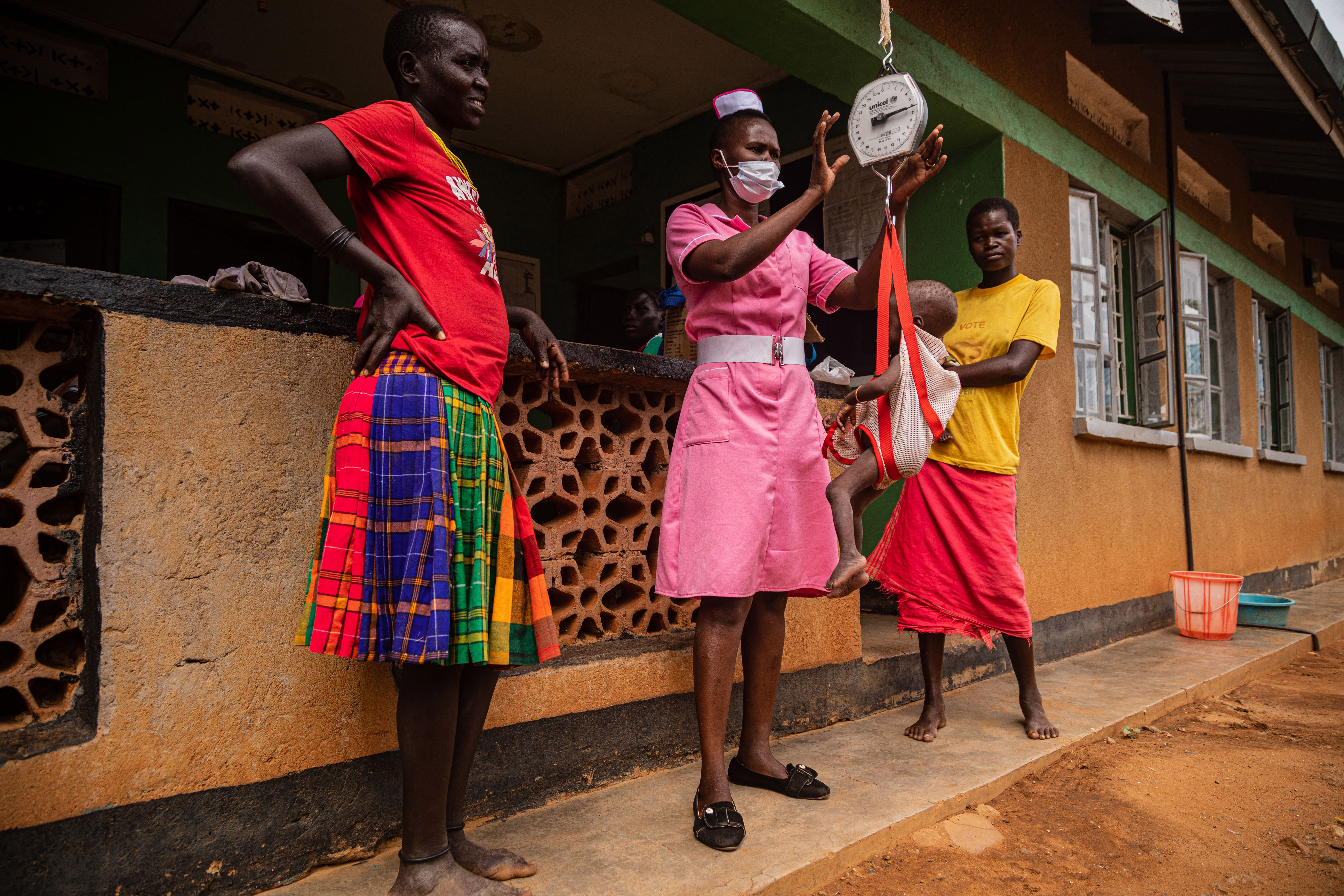 A nurse weighs a baby during a nutrition screening at Nadunget Health Centre