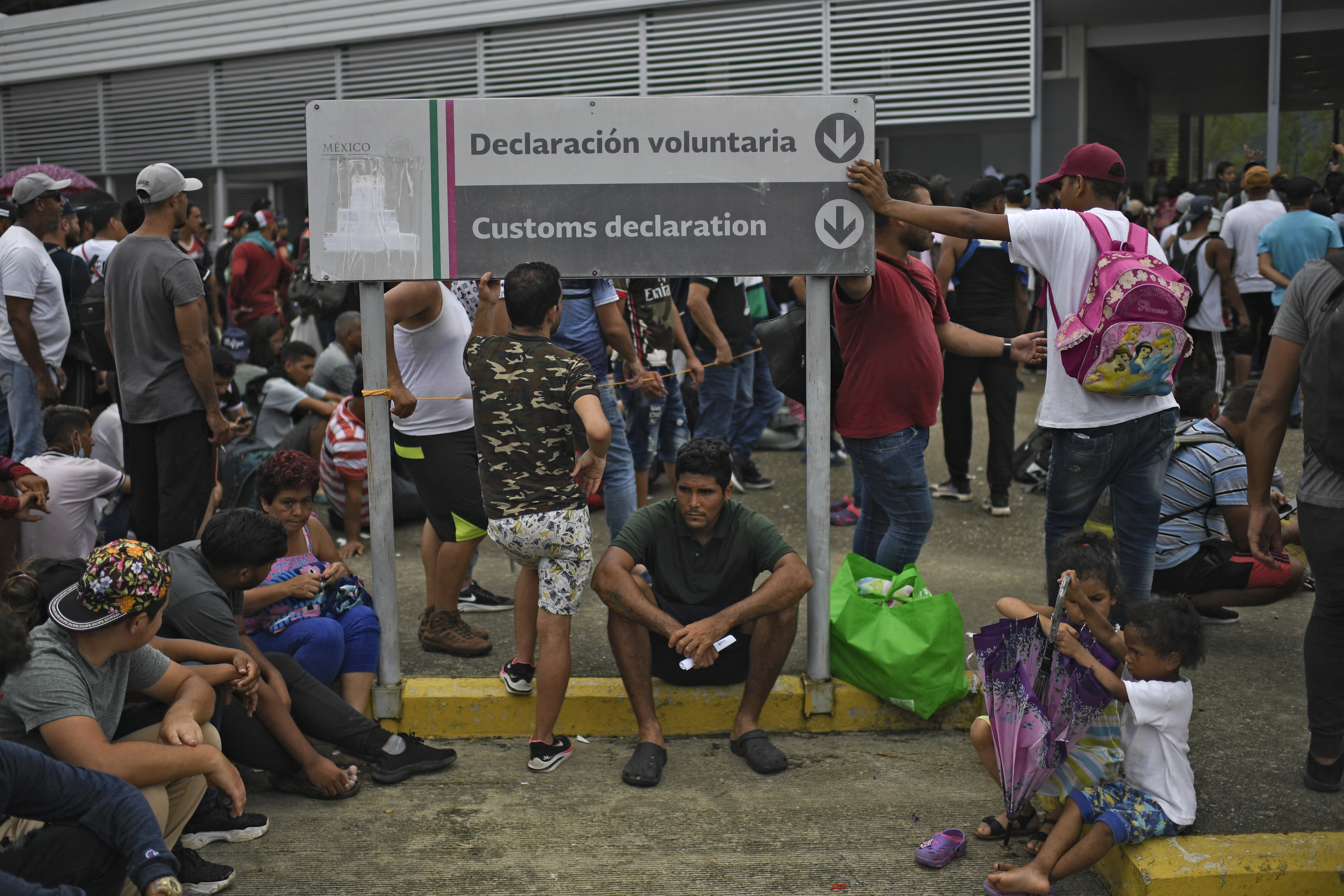 Migrants taking part in a caravan heading to the US, wait for transit visas at the immigration station in Huixtla