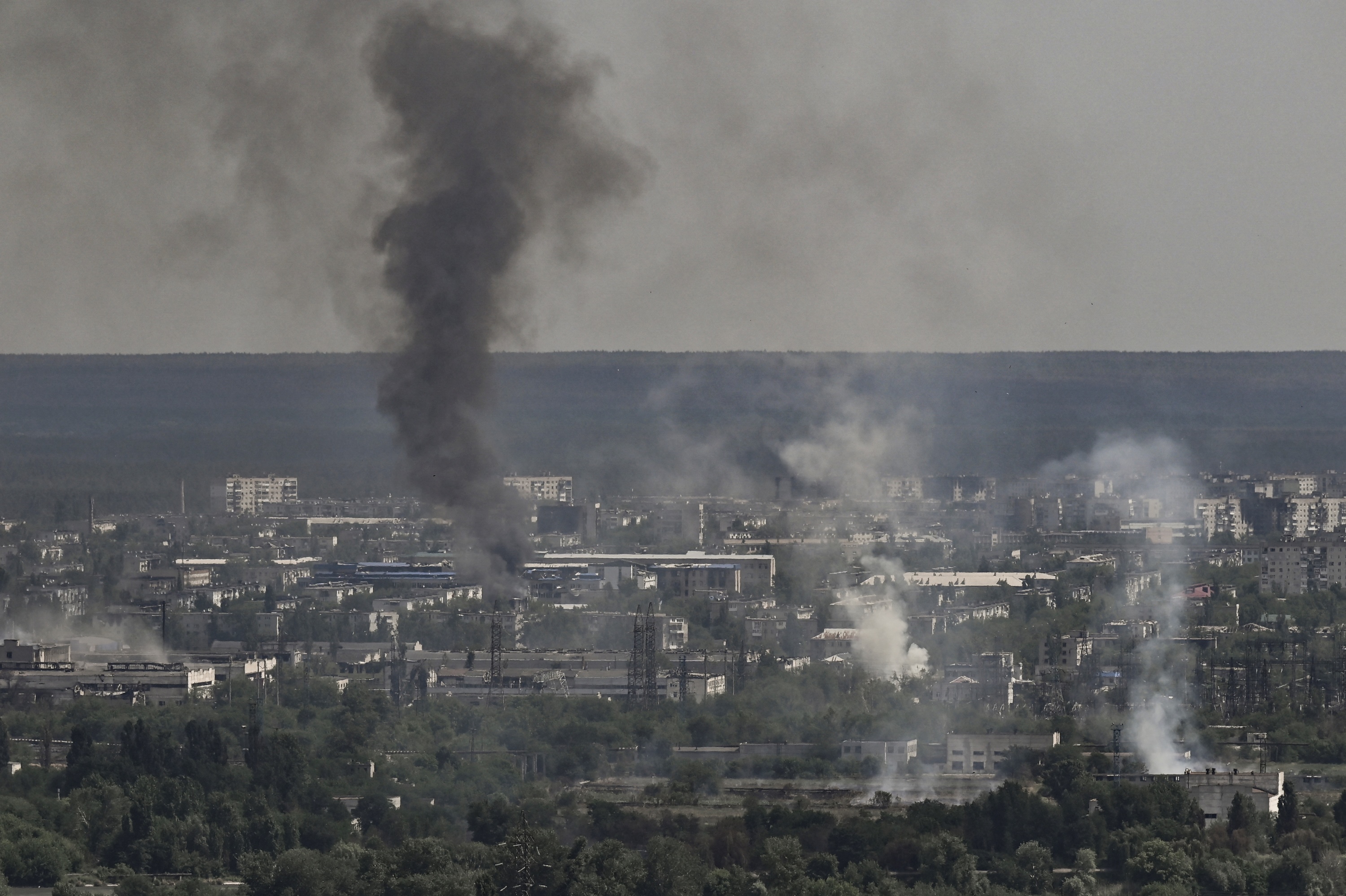 Smoke and dirt rise from the city of Severodonetsk during fighting between Ukrainian and Russian troops at the eastern Ukrainian region of Donbas on June 14, 2022, amid Russian invasion of Ukraine. - The cities of Severodonetsk and Lysychansk, which are separated by a river, have been targeted for weeks as the last areas still under Ukrainian control in the eastern Lugansk region. (Photo by ARIS MESSINIS / AFP)