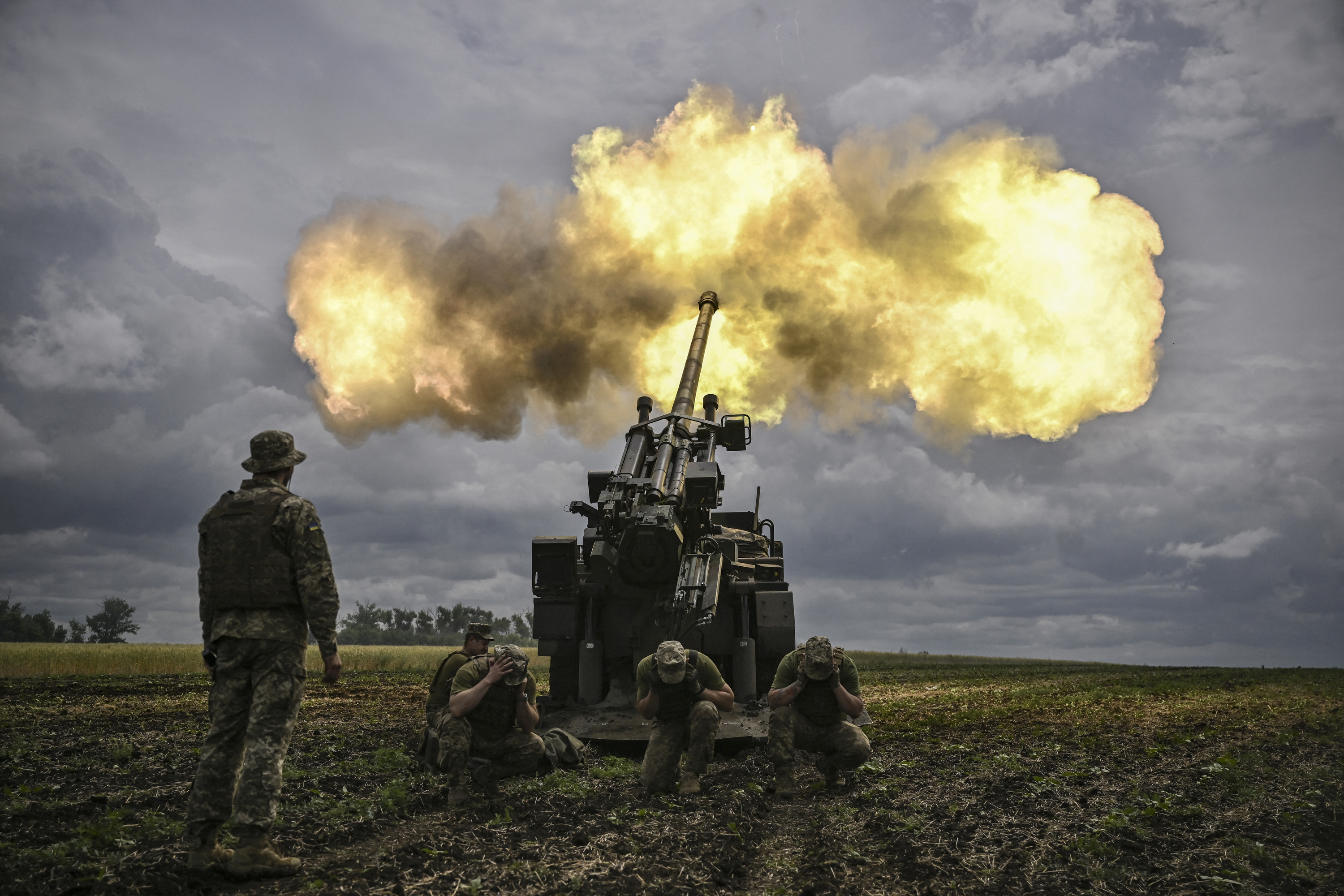 Ukrainian servicemen fire with a French self-propelled 155 mm/52-calibre gun Caesar towards Russian positions at a front line in the eastern Ukrainian region of Donbas on