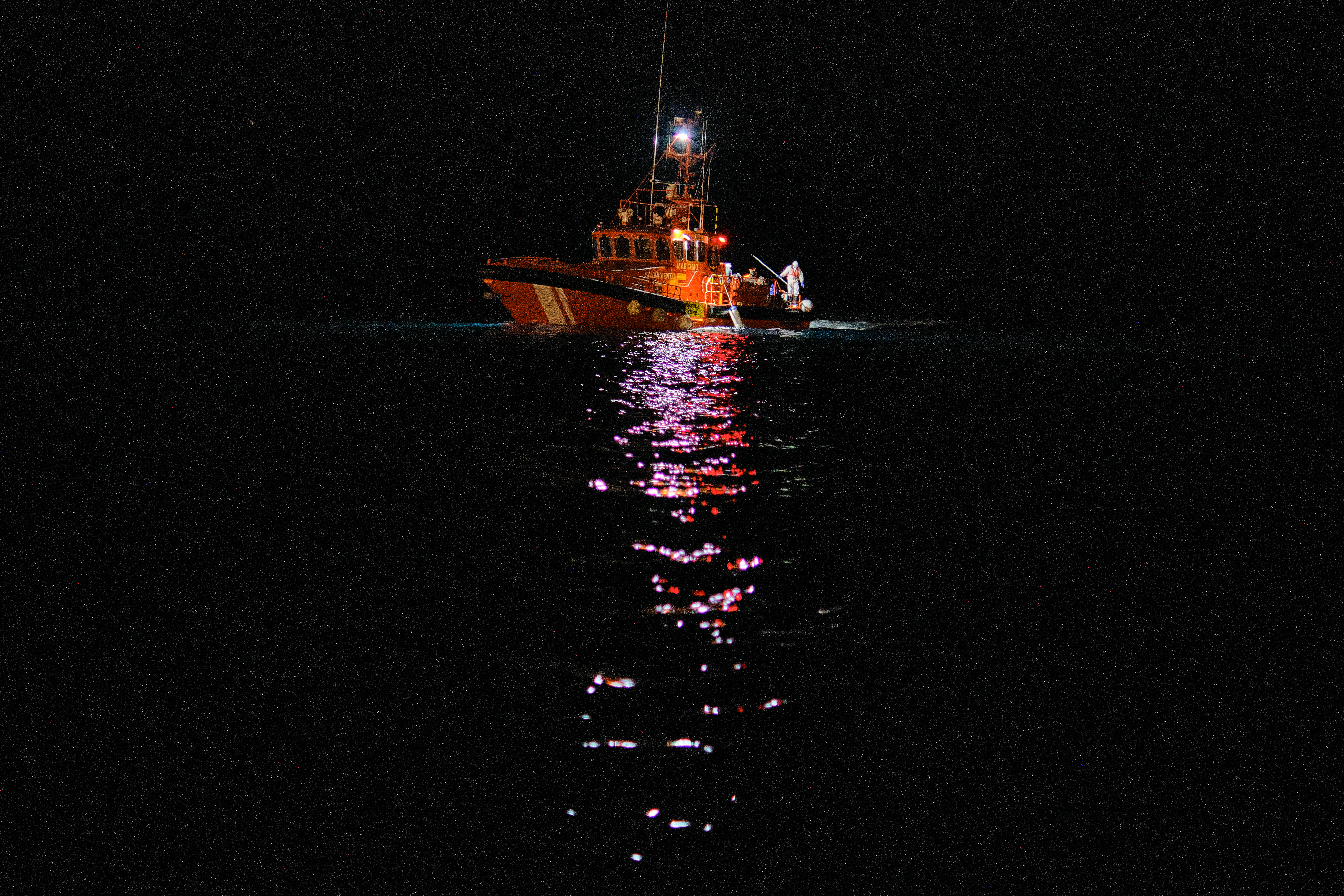 A photo of a Spanish search and rescue vessel in the dark.