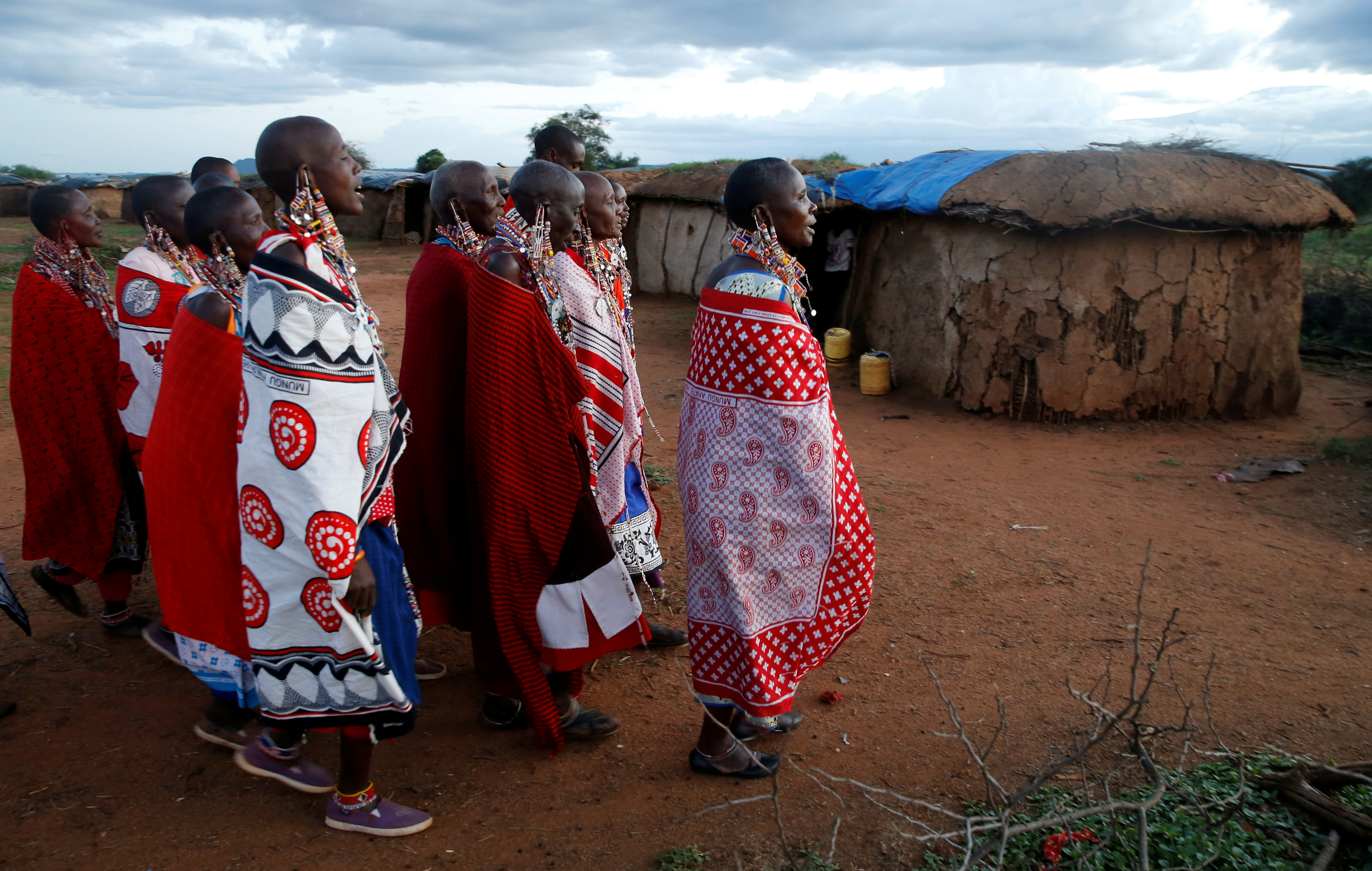Maasai women walk within the Mbirikani Manyatta at the base of Mt. Kilimanjaro, near the Kenya-Tanzania border in Kimana, Kajiado, Kenya December 14, 2018.