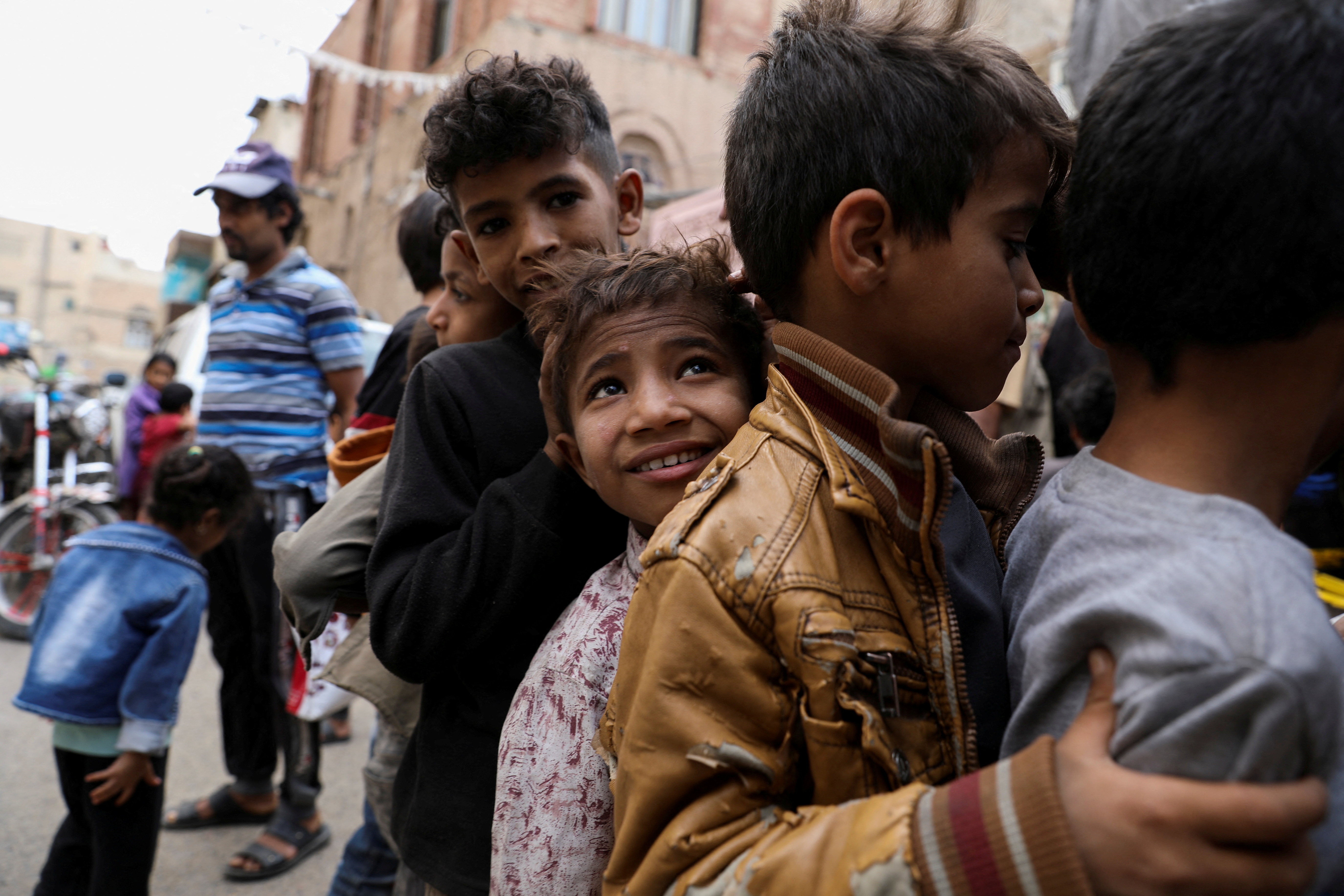 Boys stand in line as they wait to receive meals