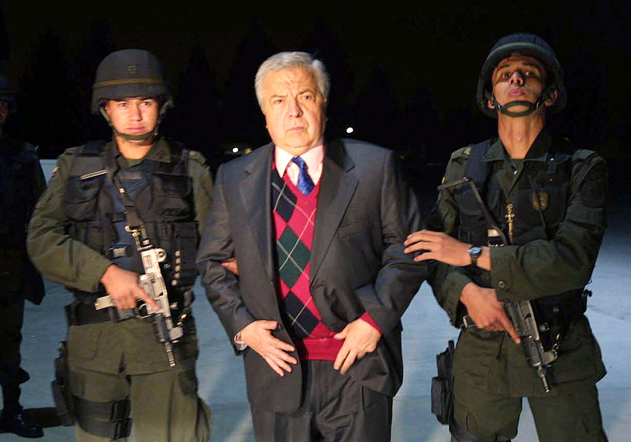 Colombian drug lord Gilberto Rodriguez Orejuela is escorted by police at Bogota's Army airport of Catam
