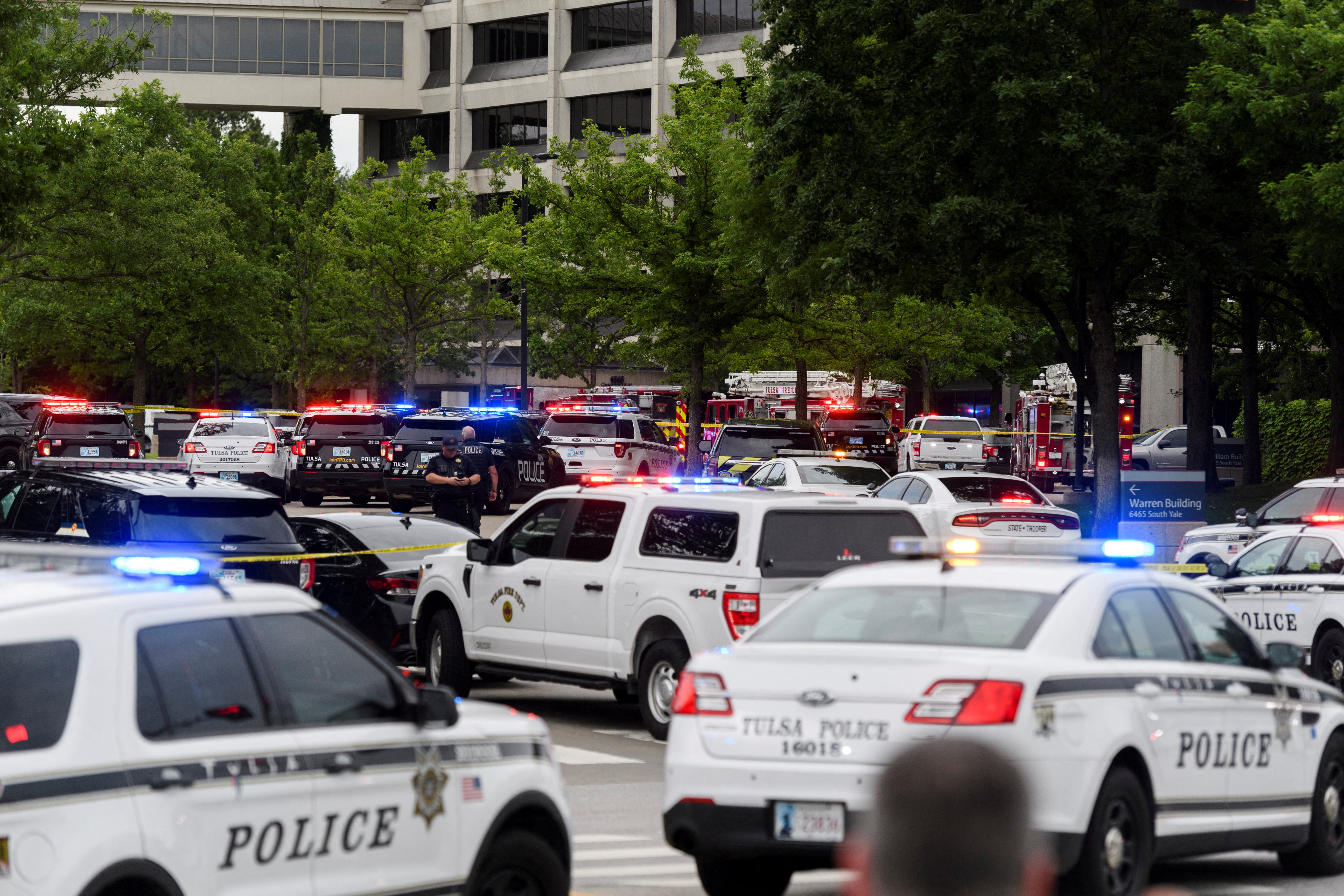 Police cars with Tulsa Police written on the vehicles queued up outside the Tulsa medical facility where a gunman killed four people