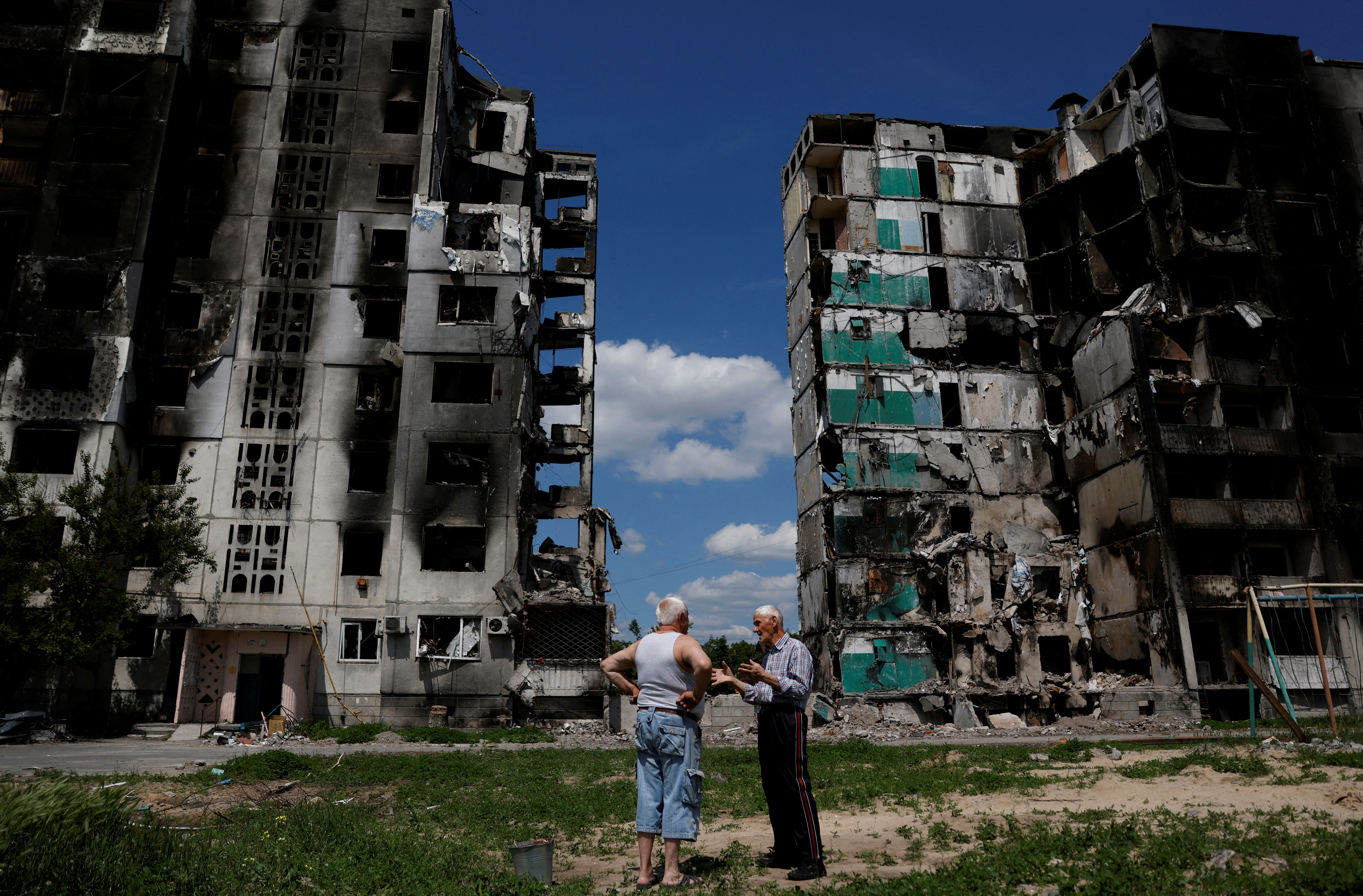Residents chat in front of a destroyed building in Borodianka, as Russia's attacks on Ukraine continue, Kyiv Region, Ukraine June 4, 2022