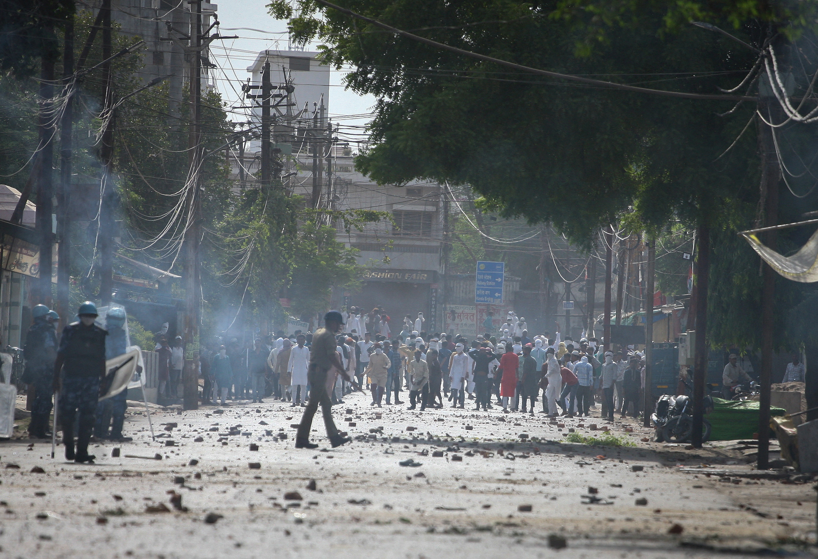 Protestors throw stones towards police during a protest demanding the arrest of Bharatiya Janata Party (BJP) member Nupur Sharma for her comments on Prophet Mohammed, in Prayagraj, India