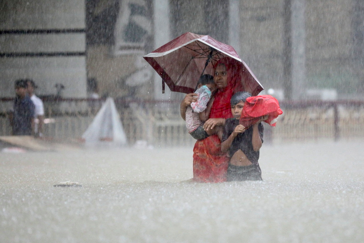 People wade through the water as they look for shelter