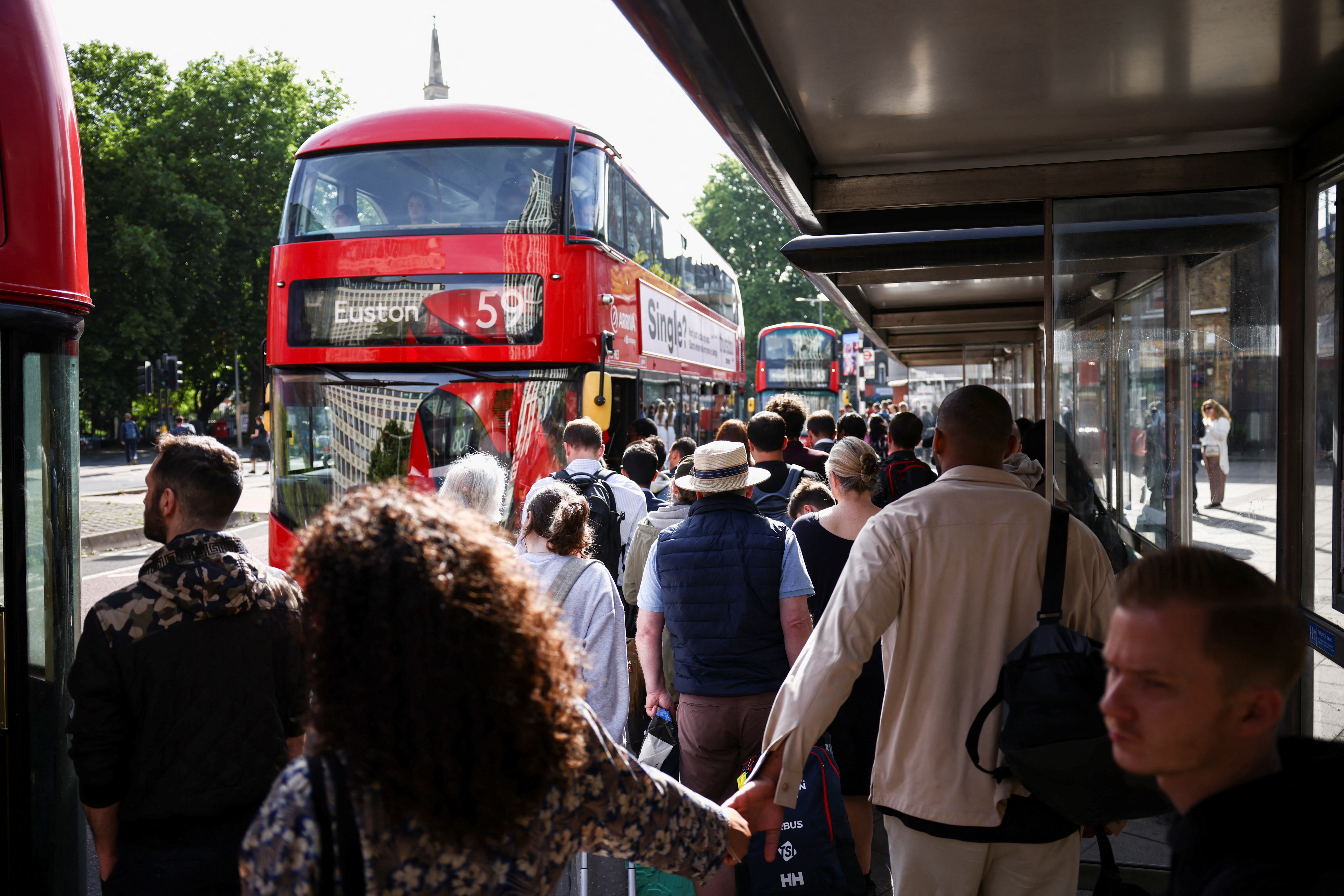 Passengers queue for a bus outside the Waterloo Station, on the first day of national rail strike in London, Britain, June 21, 2022. REUTERS/Henry Nicholls
